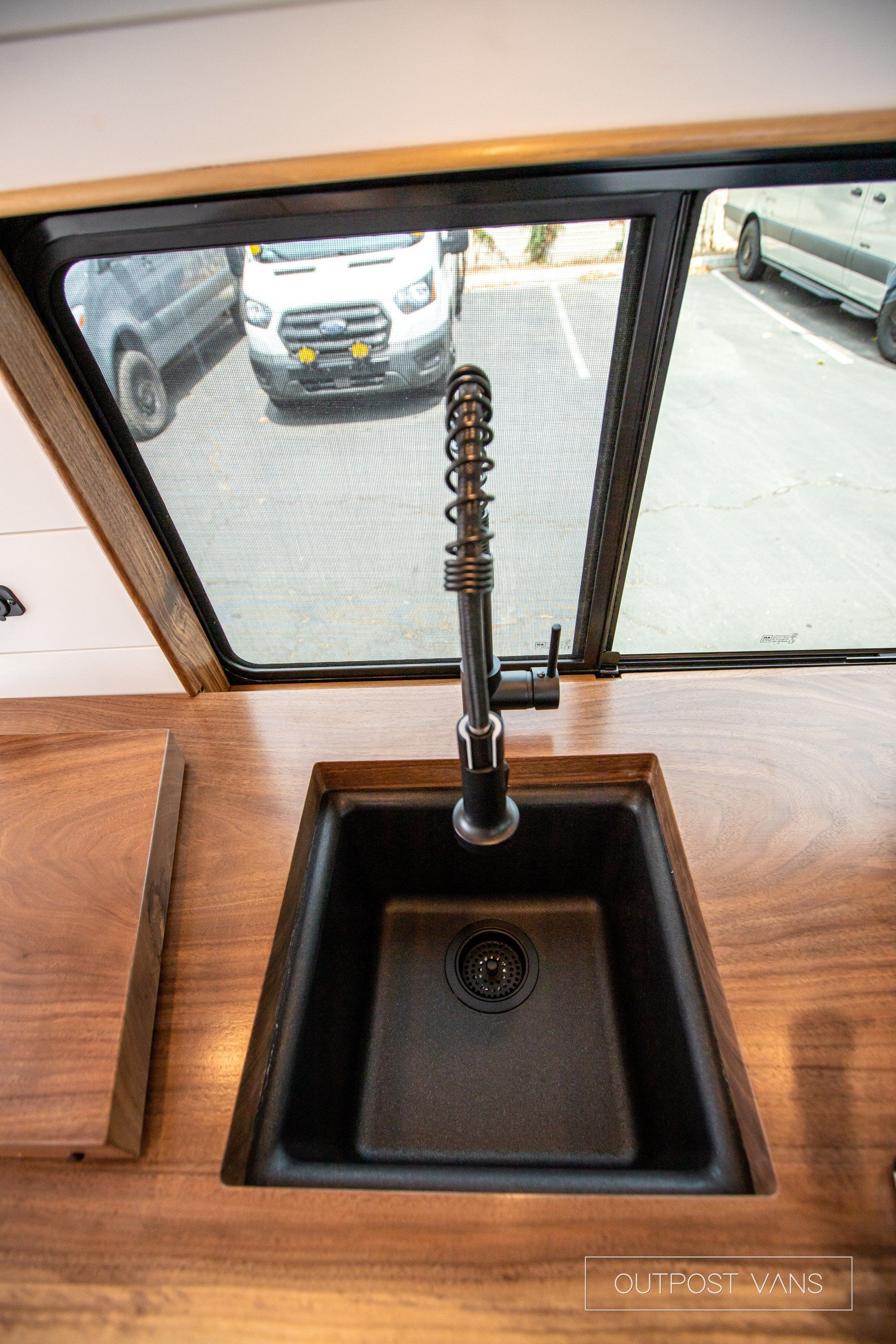 A kitchen sink with a faucet and a window.