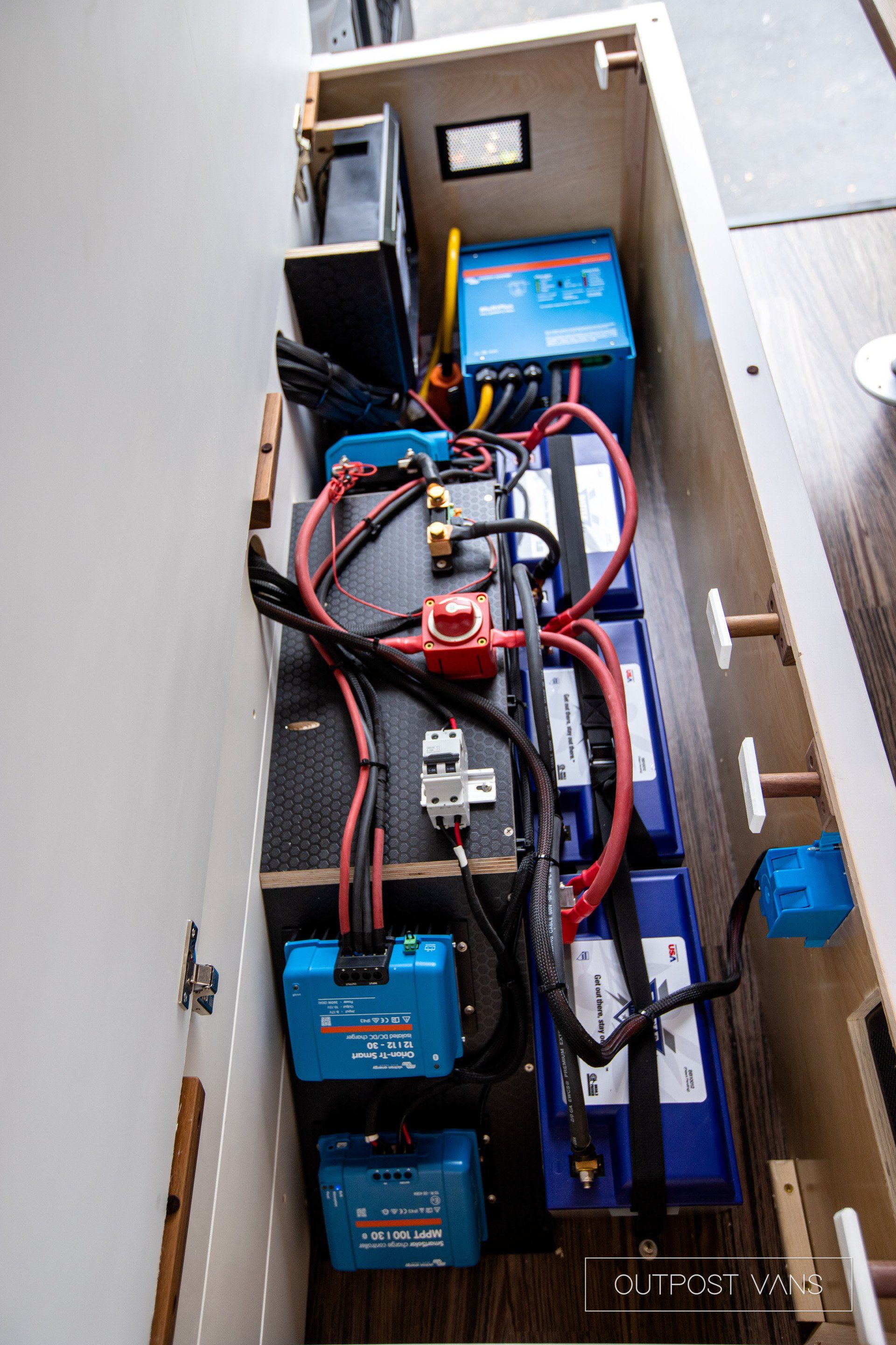 A bunch of batteries are sitting inside of a cabinet.