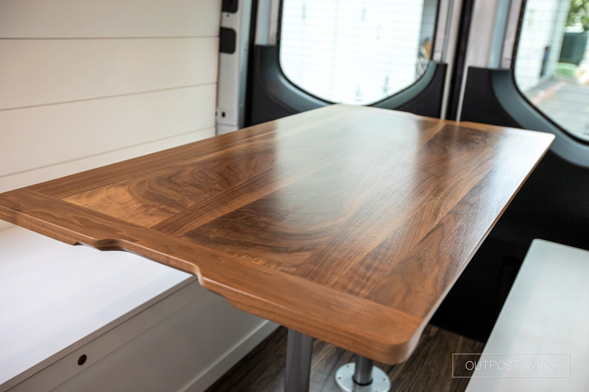 A wooden table is sitting in the back of a van.