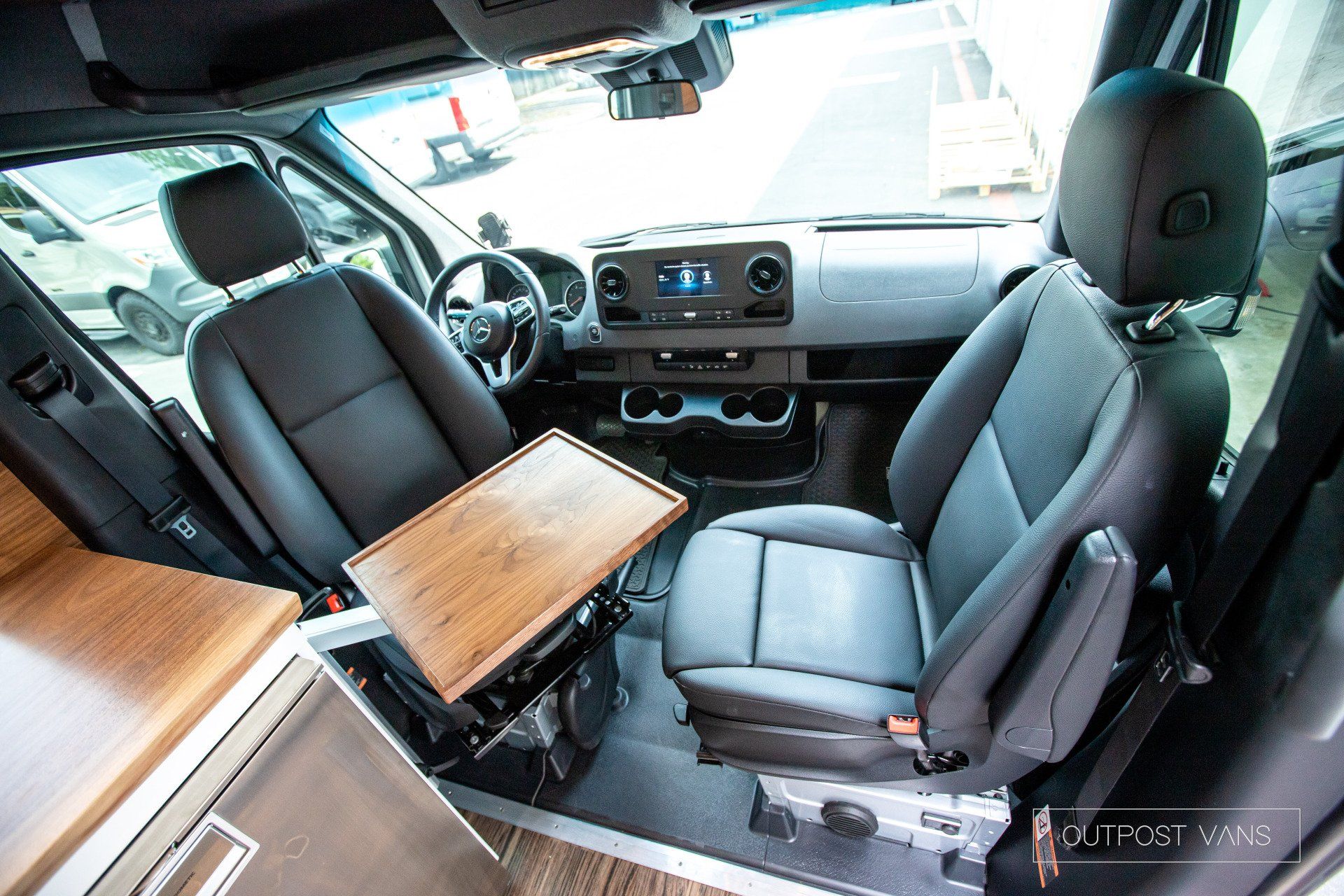 The inside of a van with a wooden table between the seats.