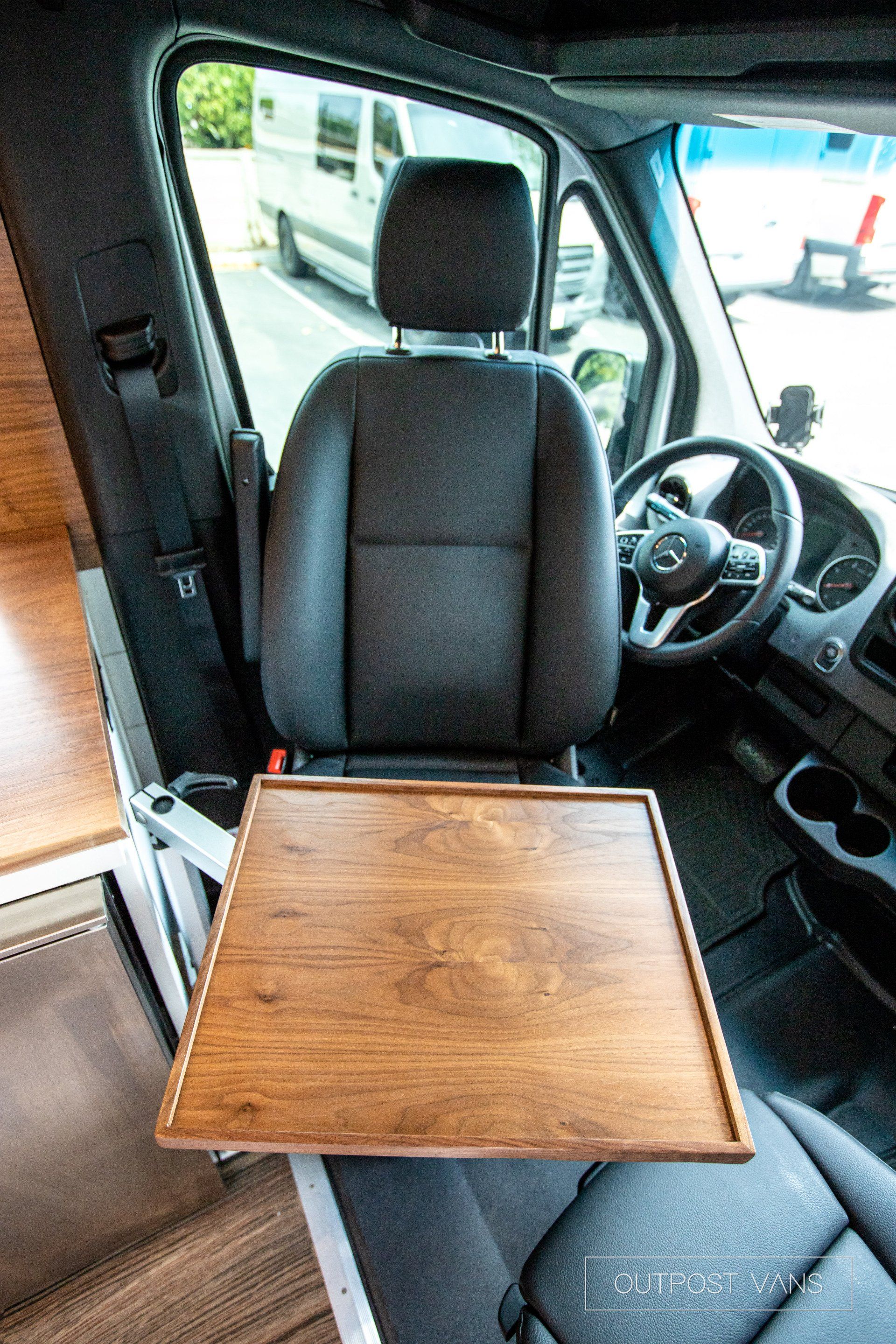 A wooden table is sitting in the back seat of a van.