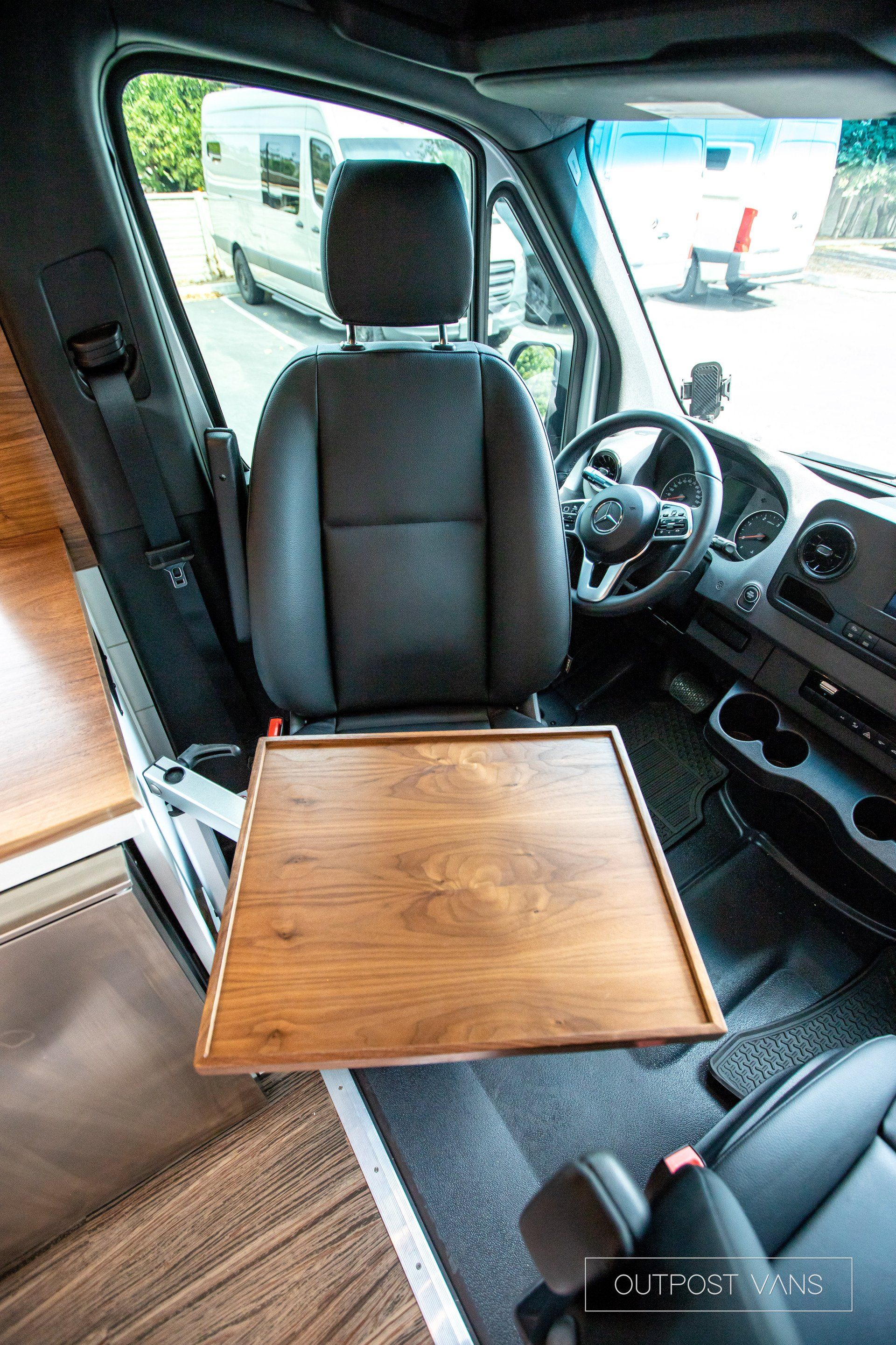 A van with a wooden table in the driver 's seat.