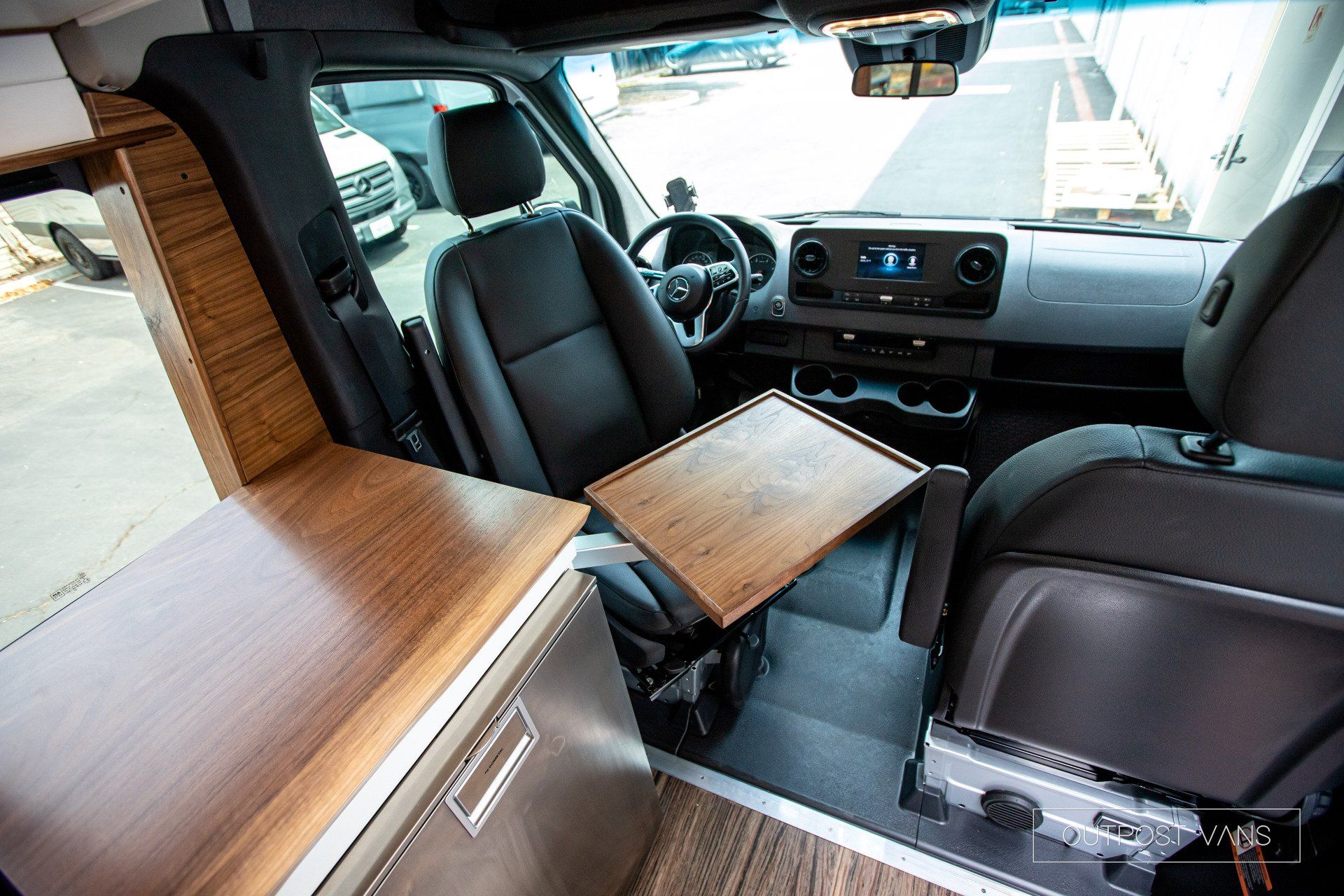 The interior of a van with a wooden table between the seats.