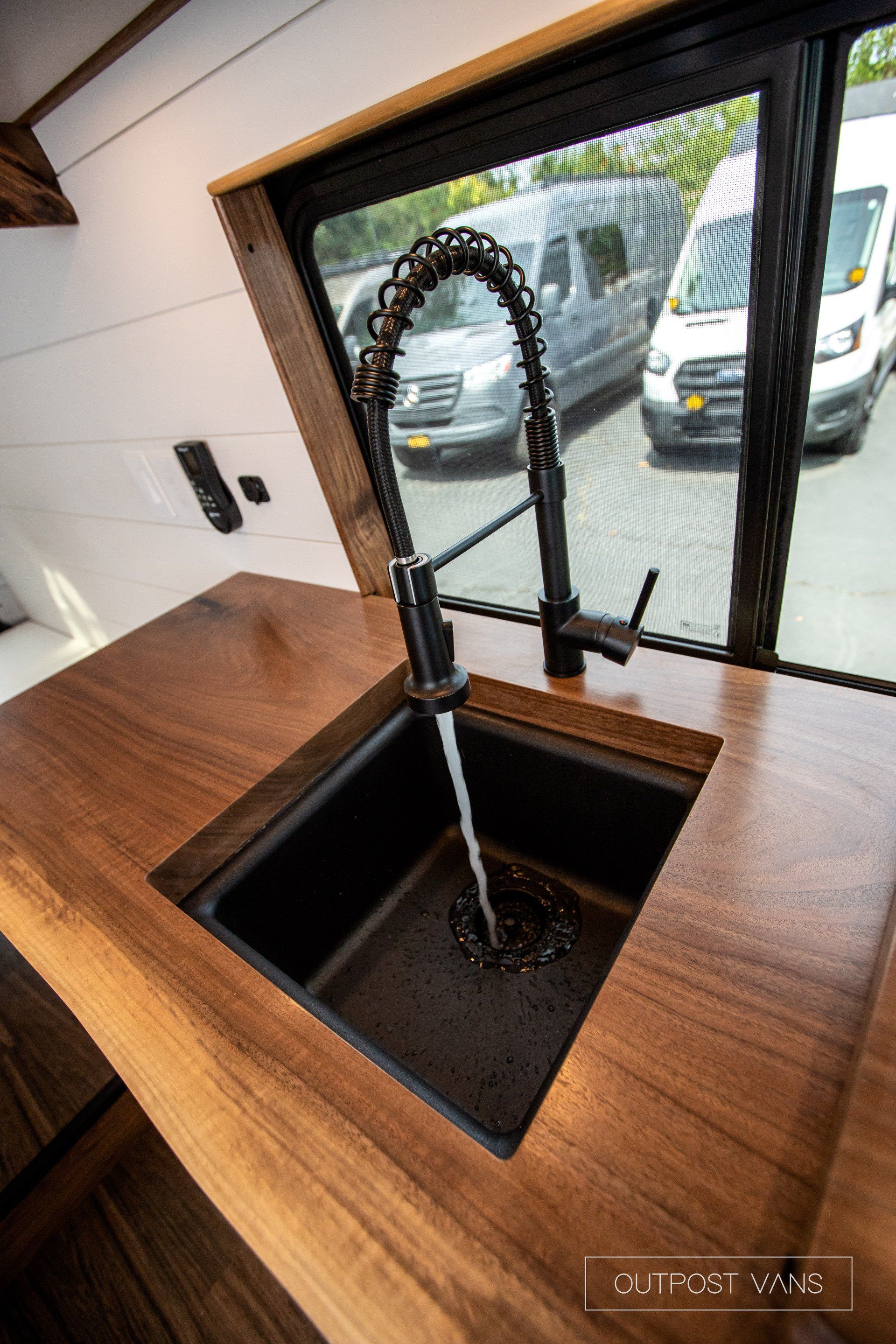 A kitchen sink with a faucet and a window.