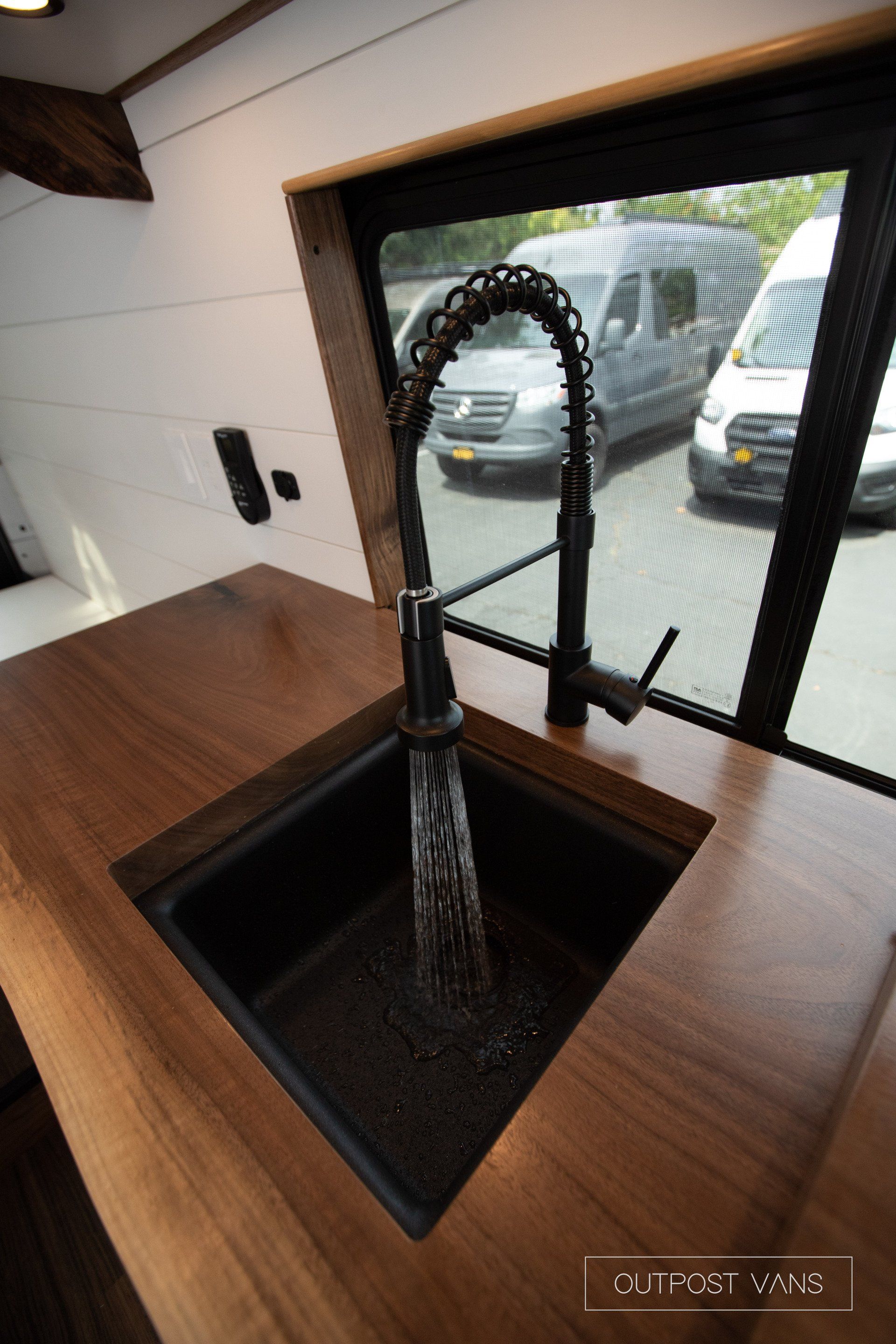 A kitchen sink with a faucet and a window.