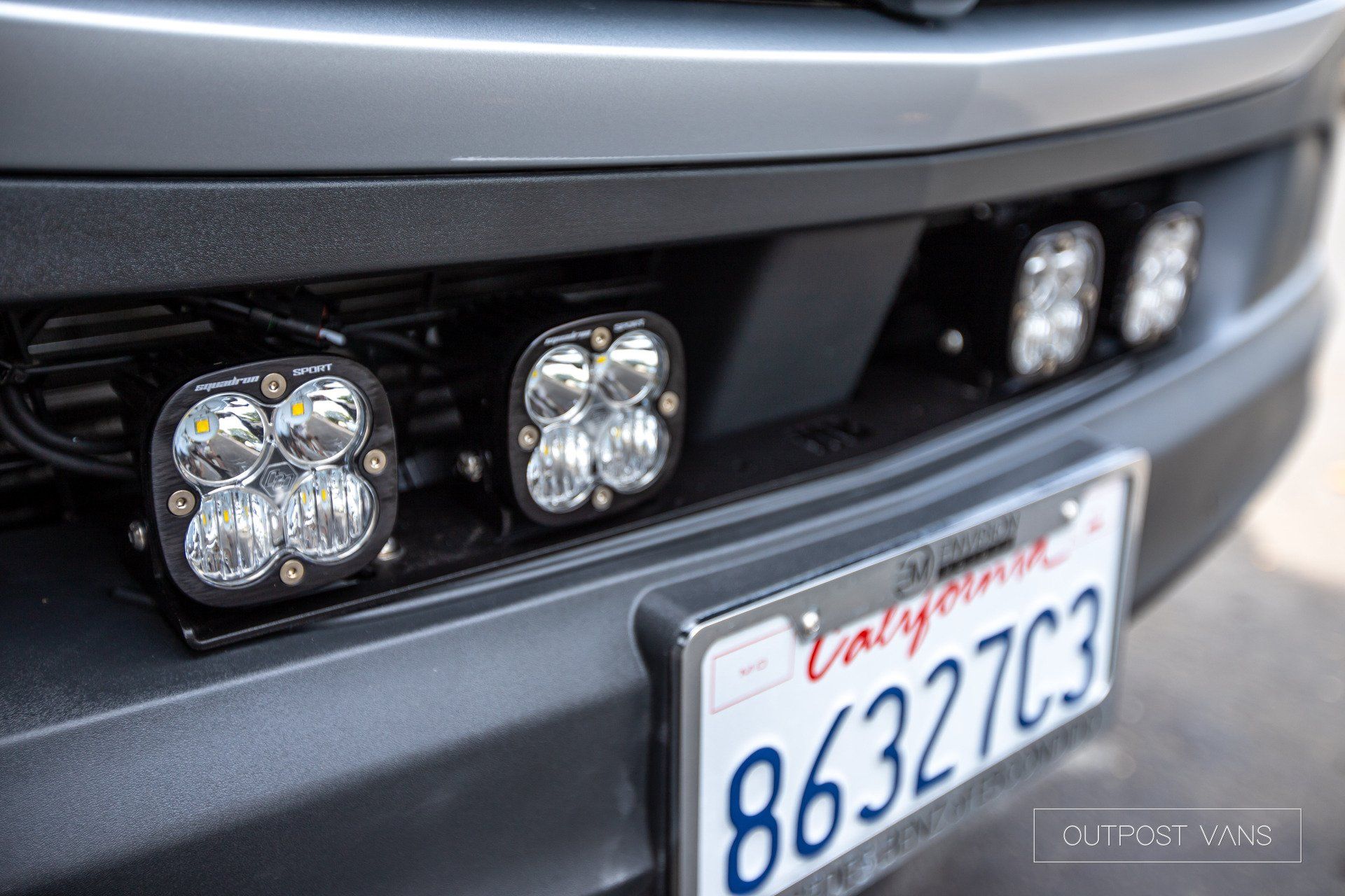A close up of the front of a truck with a california license plate.