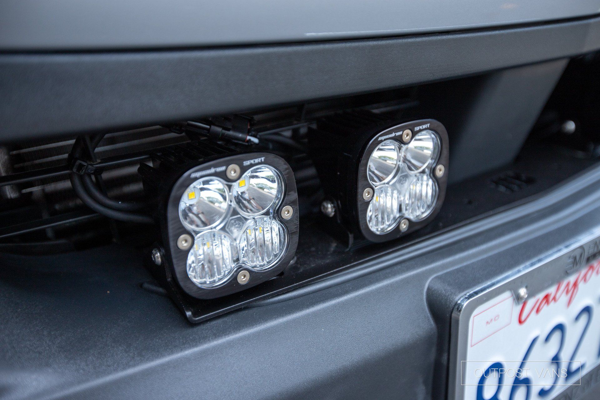 A close up of the front of a car with two lights on it.