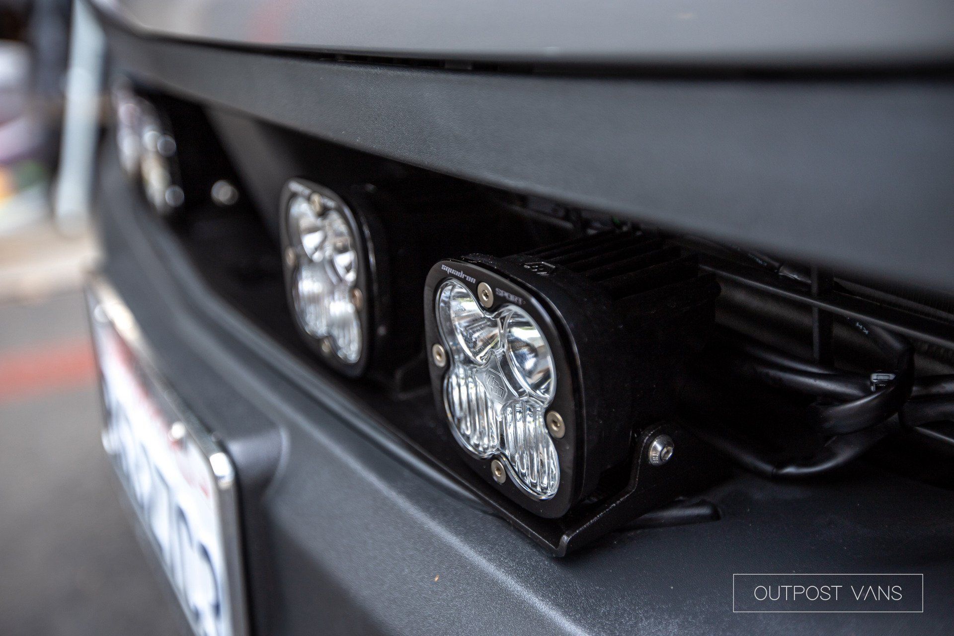 A close up of the front of a car with lights on it.