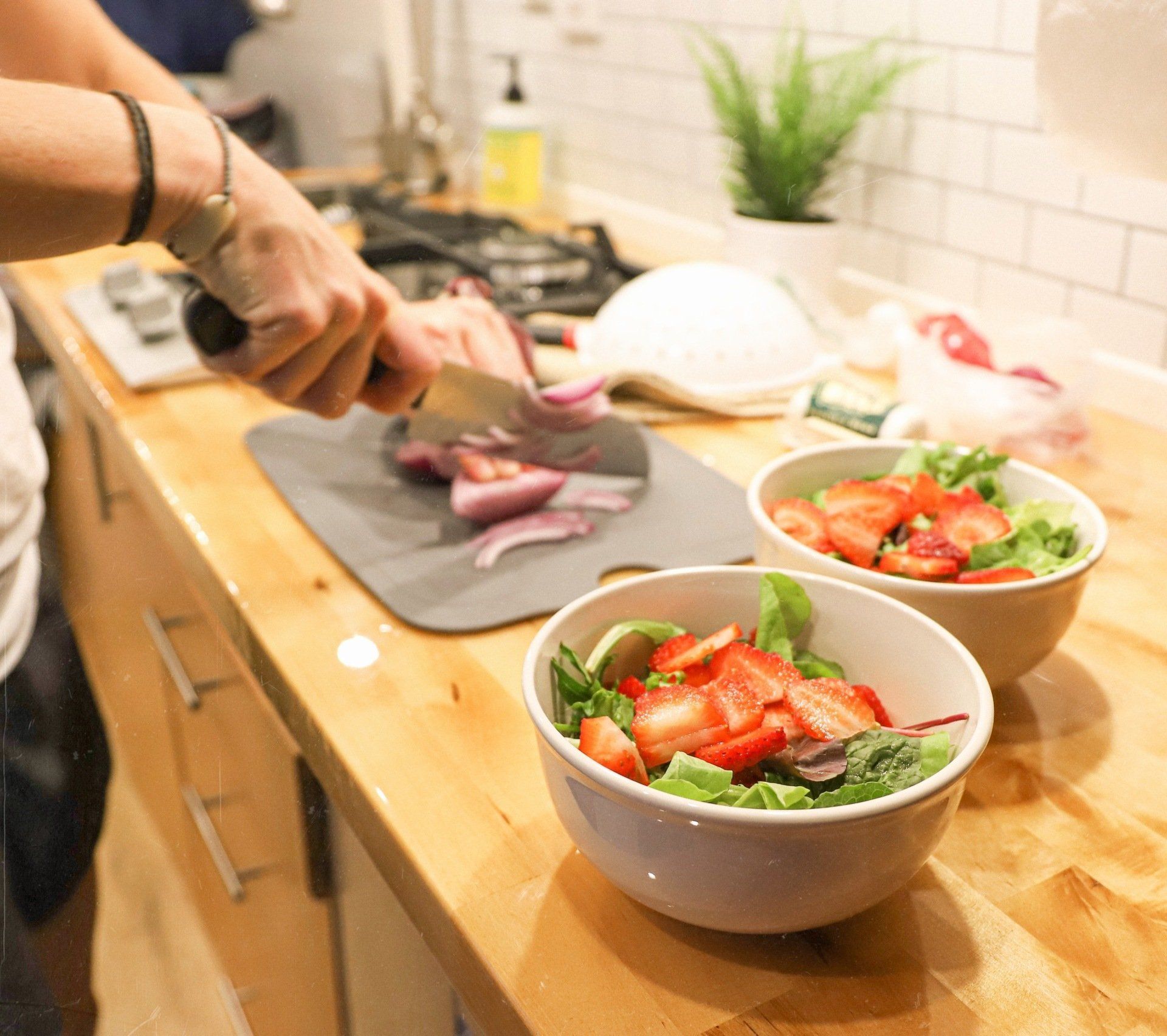 a person is cutting onions on a cutting board in a kitchen