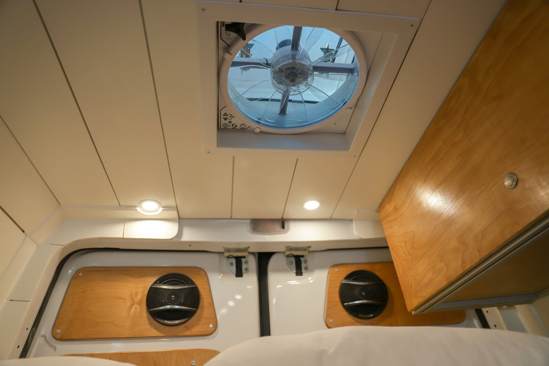 a bedroom in a van with a ceiling fan and a bed .