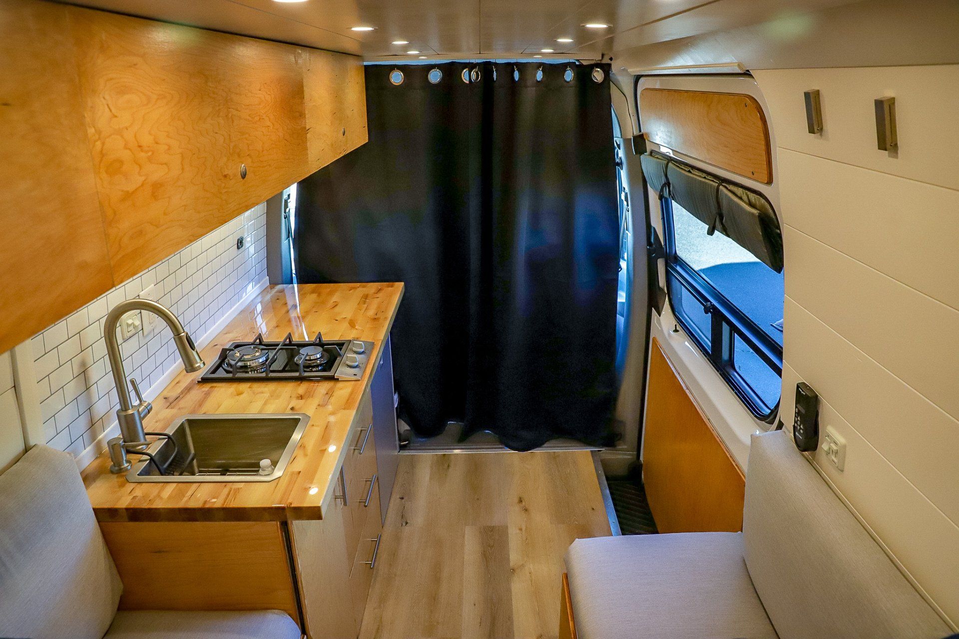 the inside of a camper van with a sink and stove .