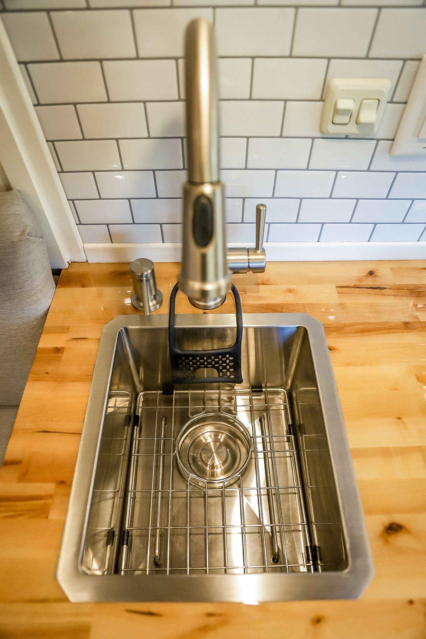 a stainless steel sink with a faucet on a wooden counter top .