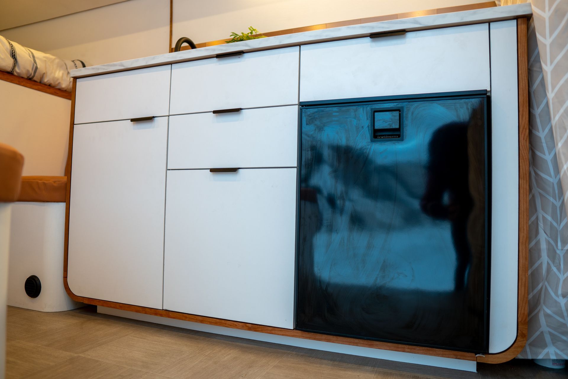 A kitchen with white cabinets and a black refrigerator.