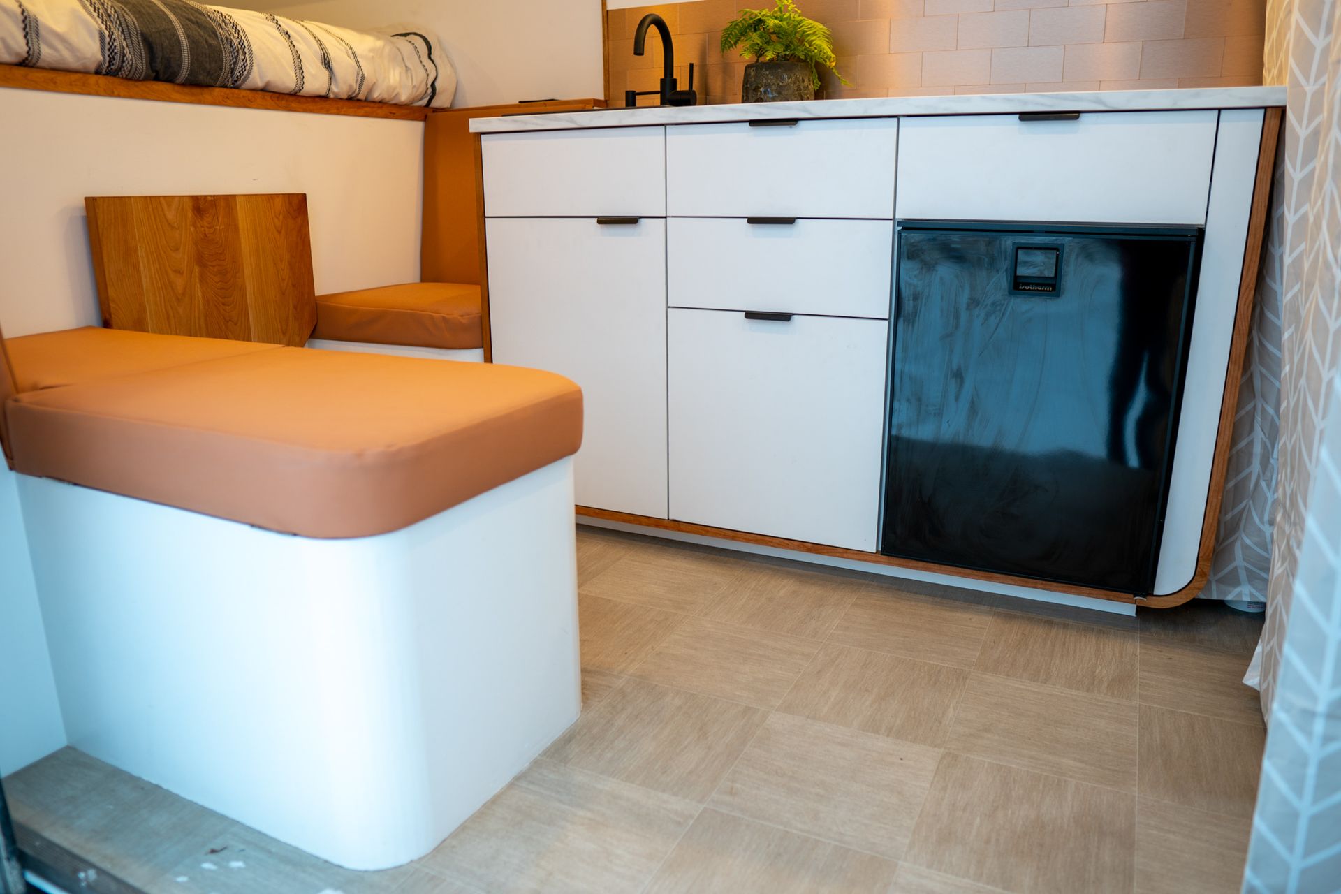 A kitchen with white cabinets , drawers , a sink and a refrigerator.