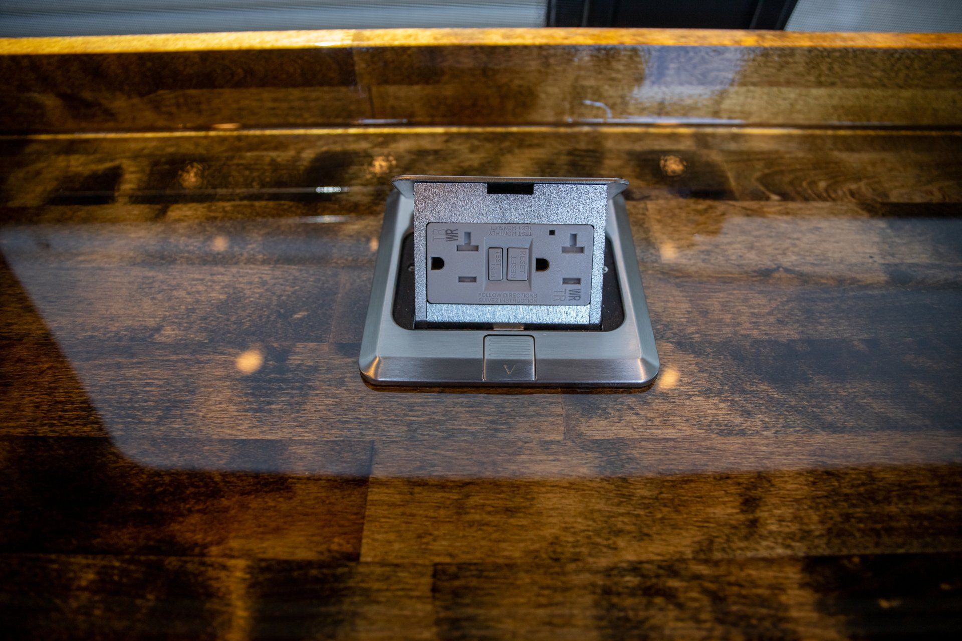 a close up of a electrical outlet on a wooden counter top .