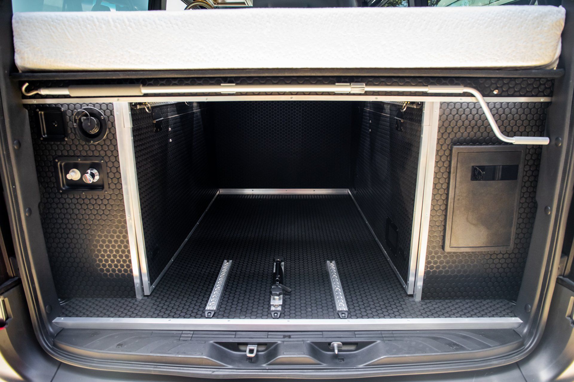 the trunk of a van has a mattress in it