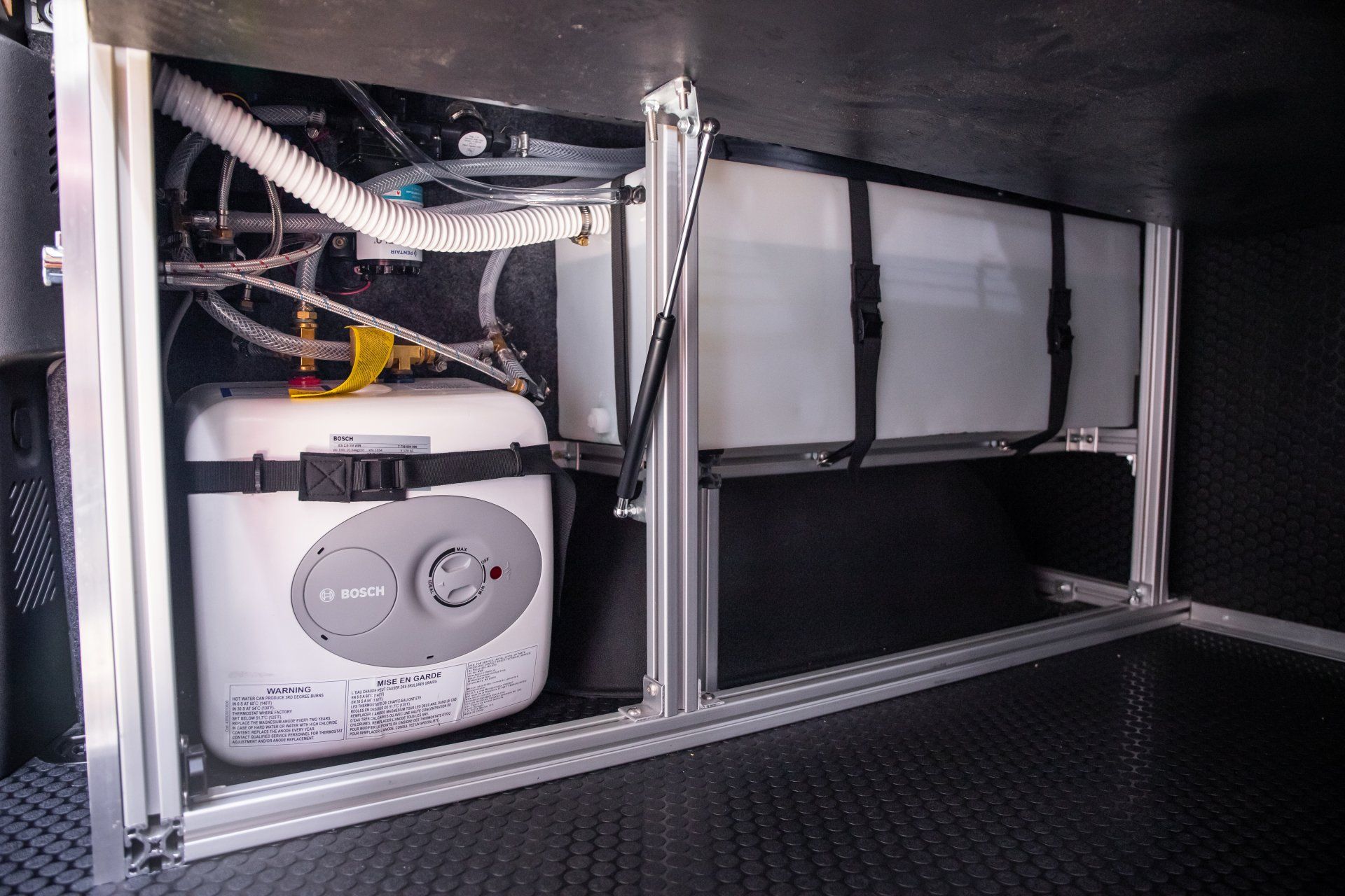 a water heater is sitting under a table in a vehicle .