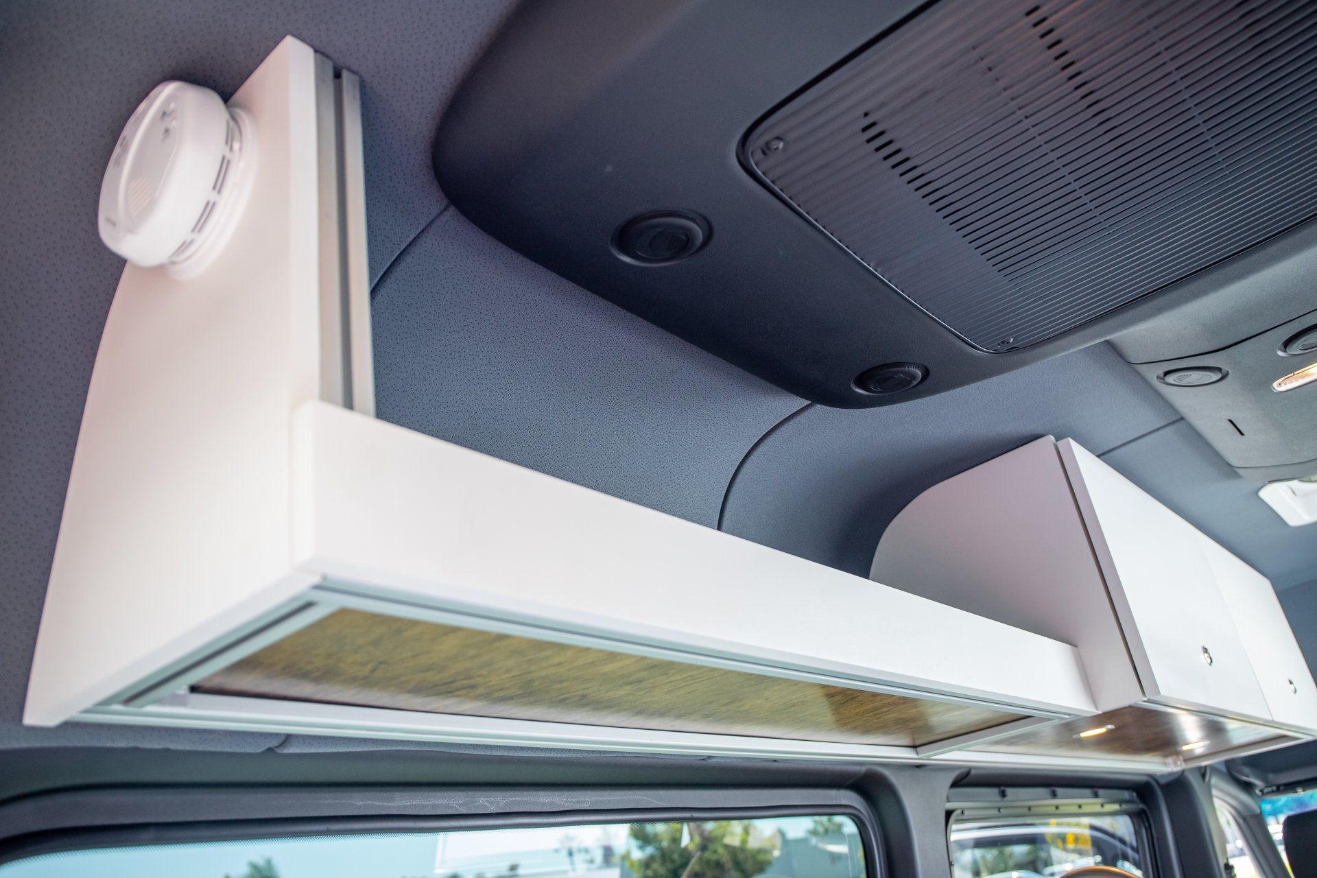 a white shelf is hanging from the ceiling of a car .