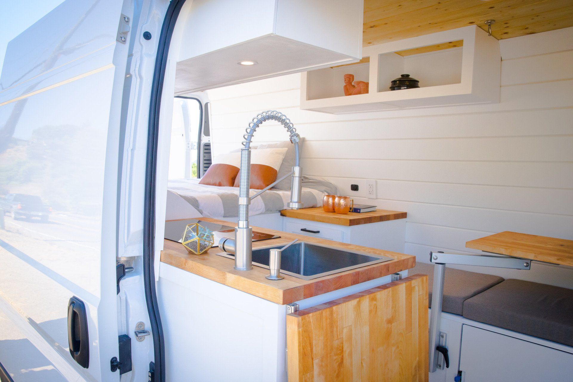 the inside of a van with a sink and a table .