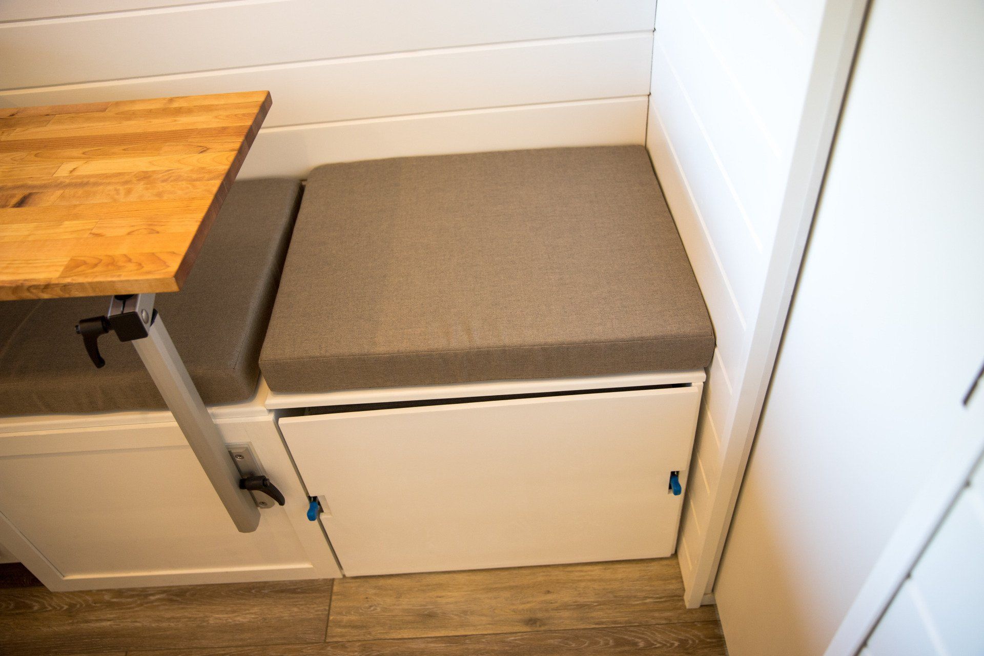 a bench with a cushion and a table in a room .