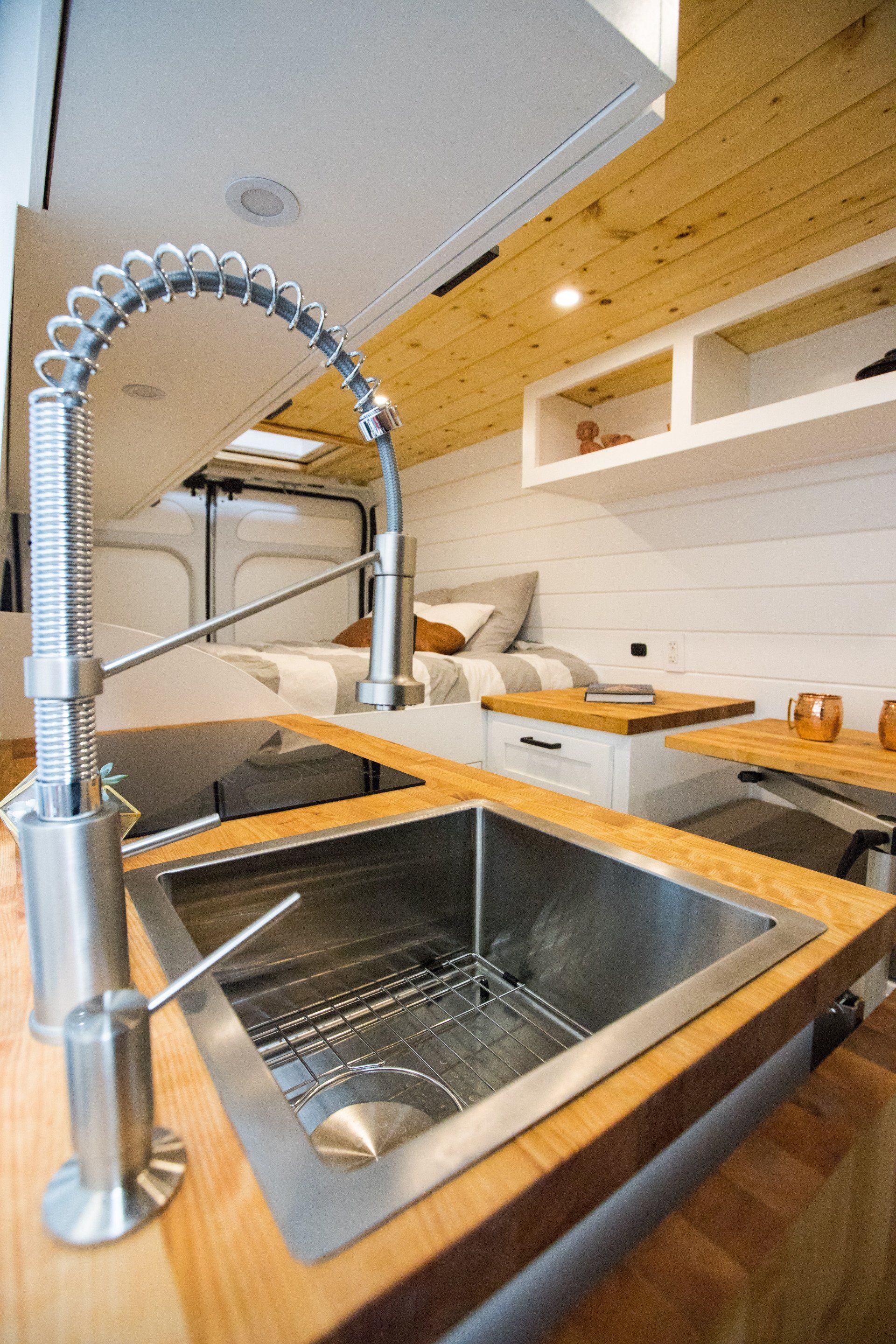 a kitchen sink with a faucet on a wooden counter top .