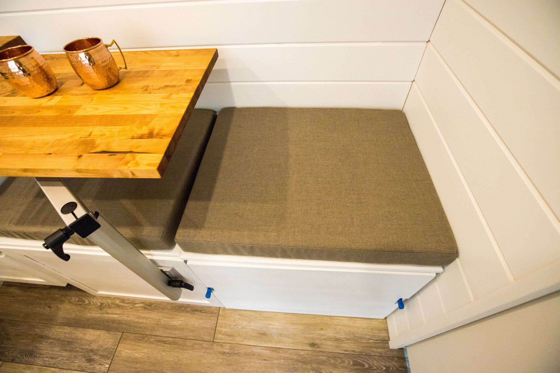 a wooden table is sitting on top of a bench next to a wall .