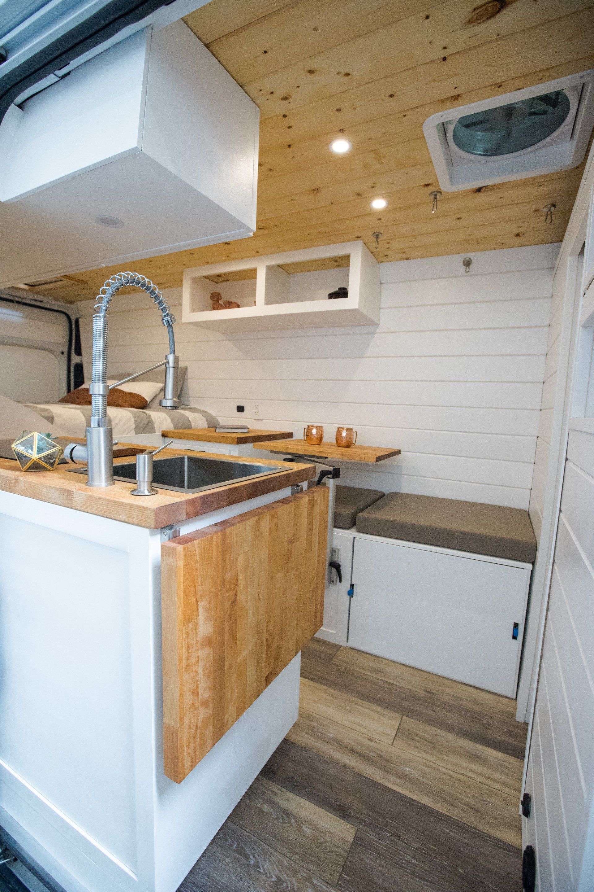 a kitchen in a van with a sink and a table .