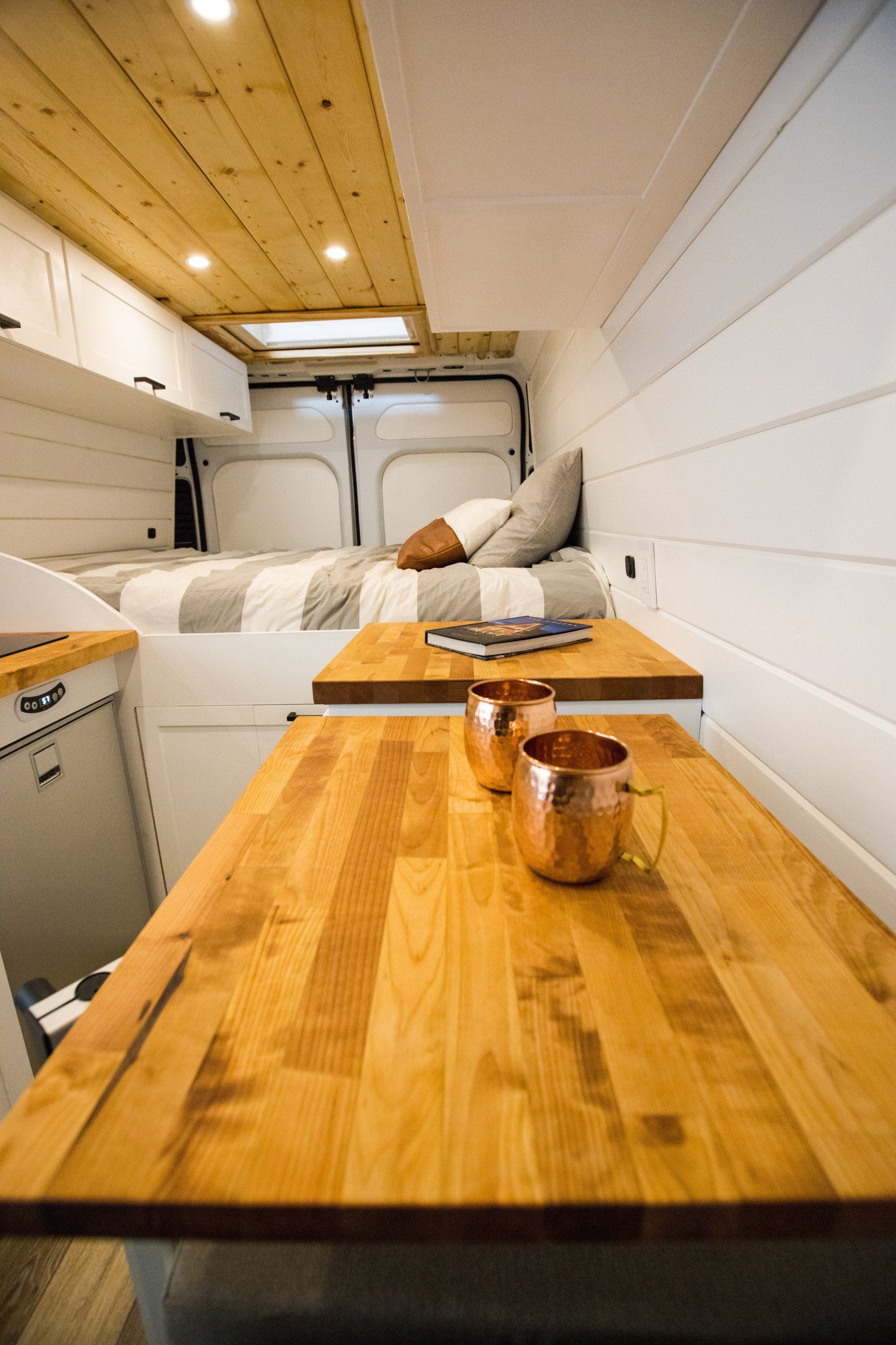 a wooden table with two cups on it in a van .