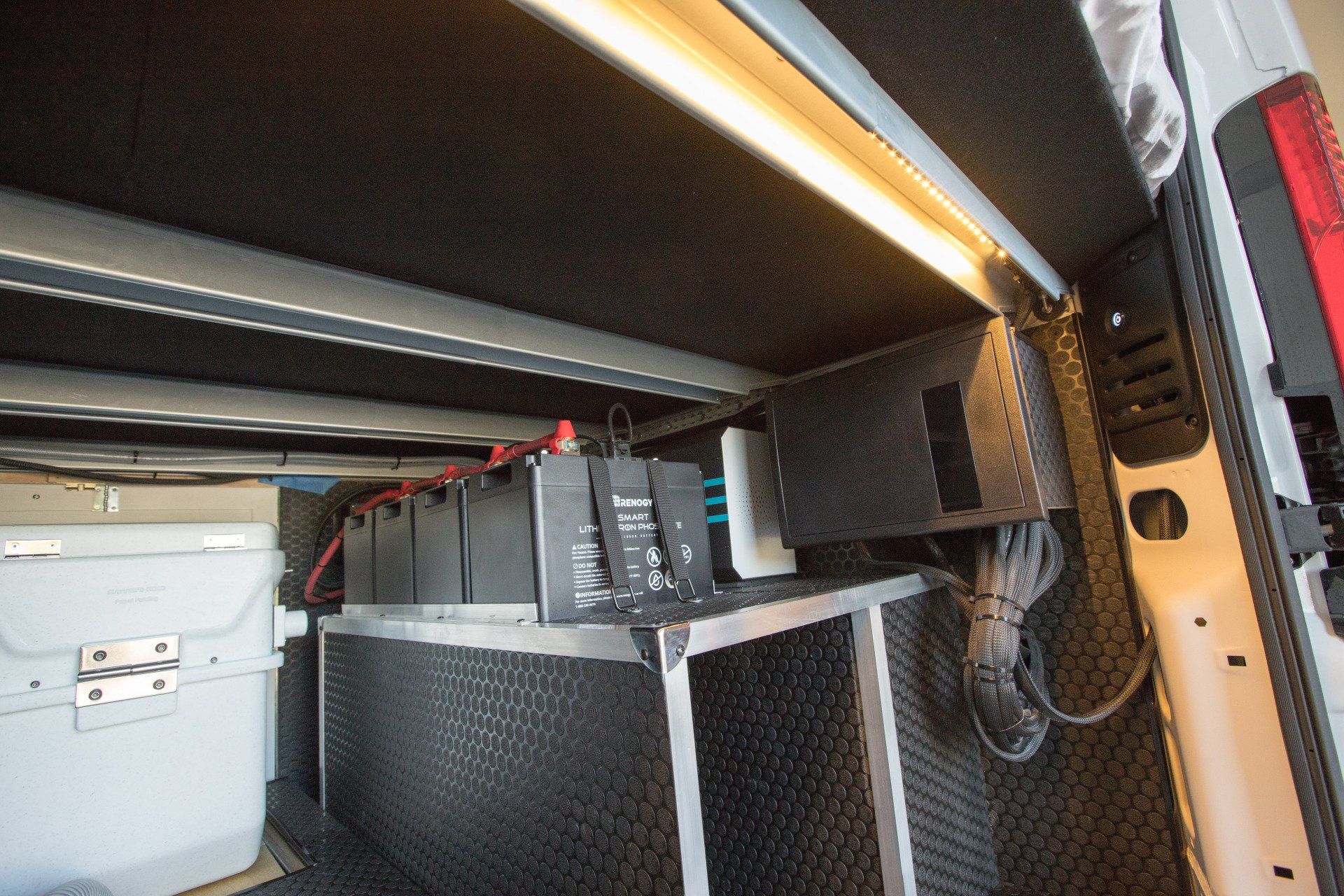 the inside of a van with a cooler and electrical equipment