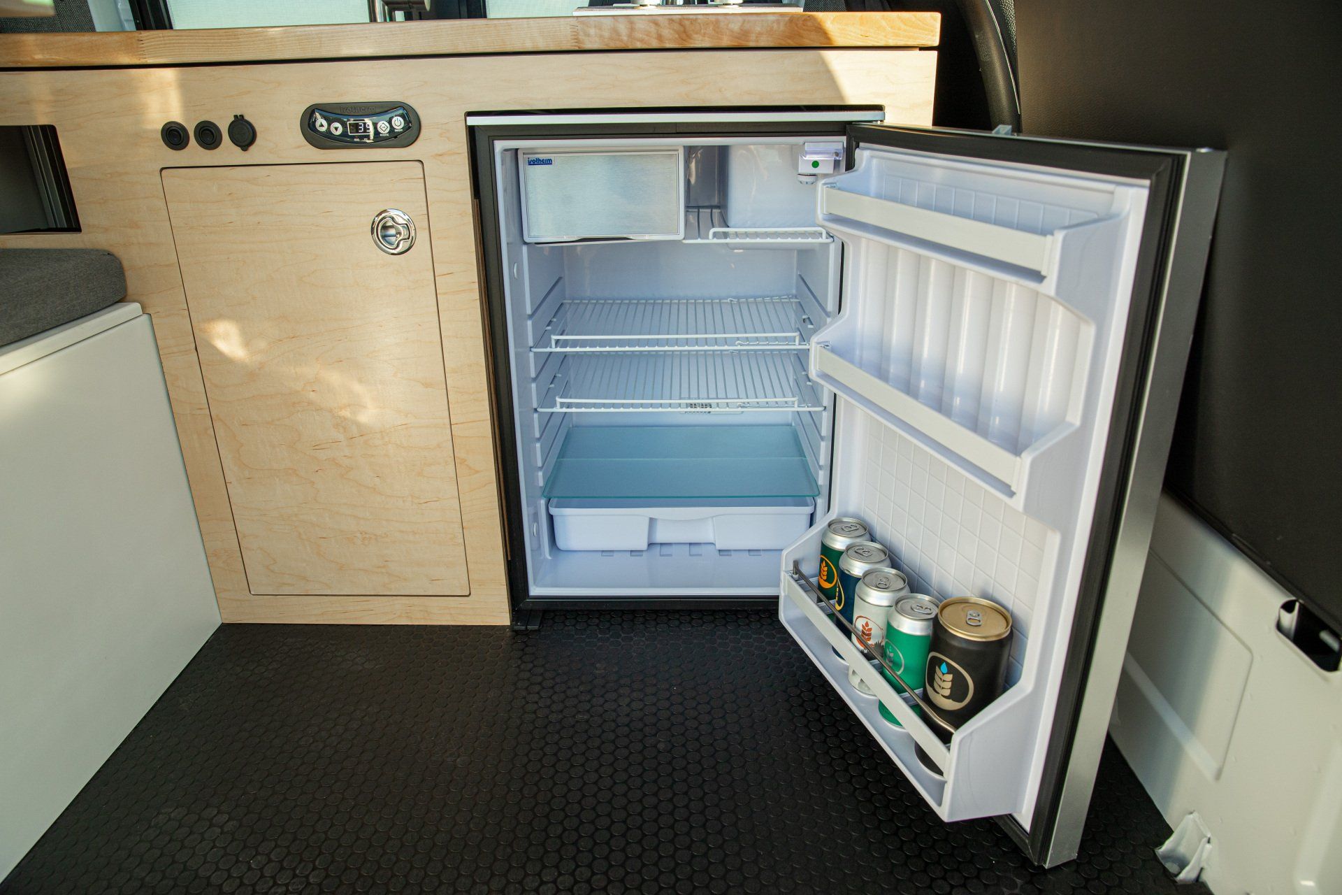 an empty refrigerator in a van with the door open
