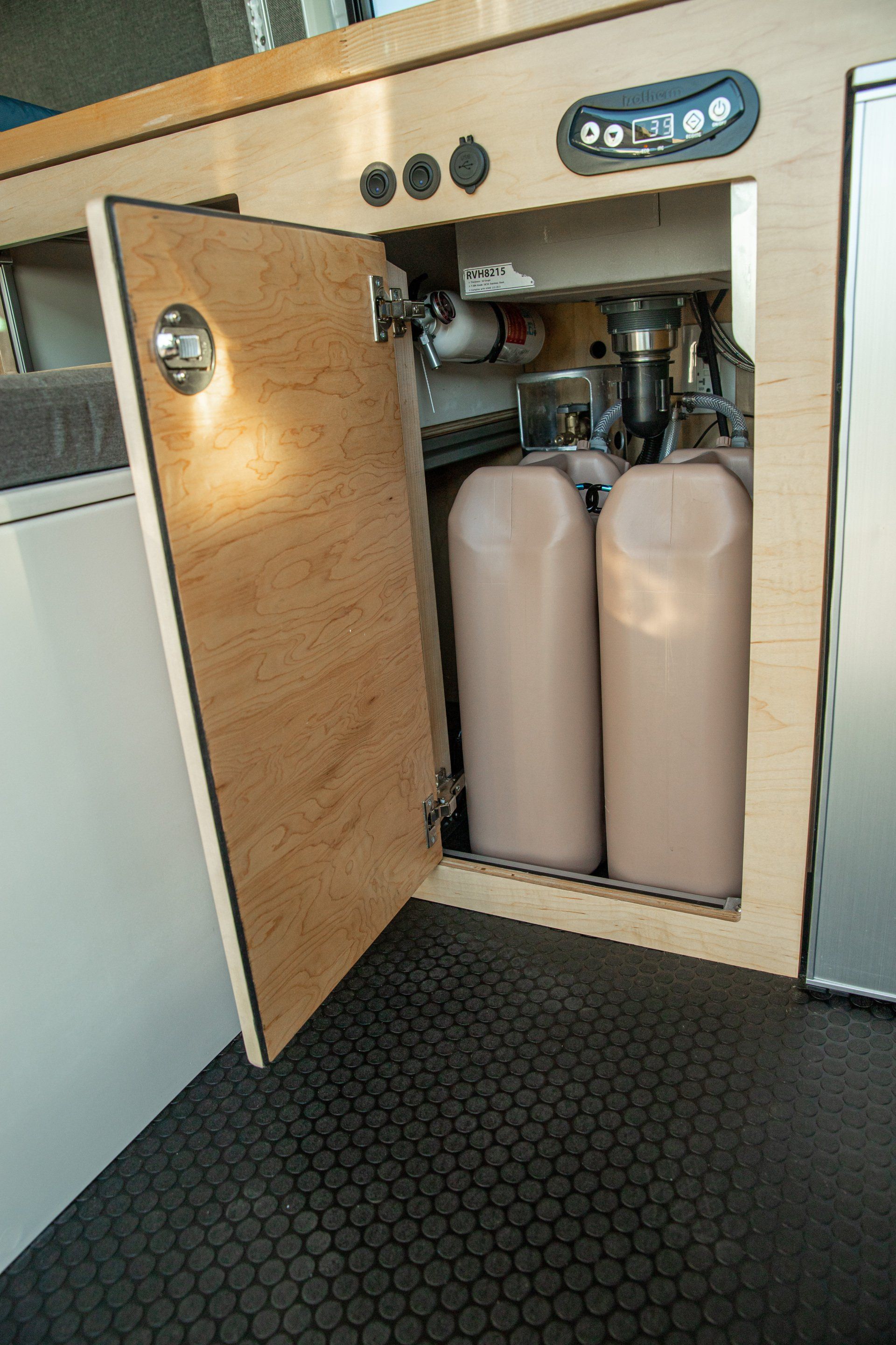 a kitchen cabinet with two propane tanks inside of it .