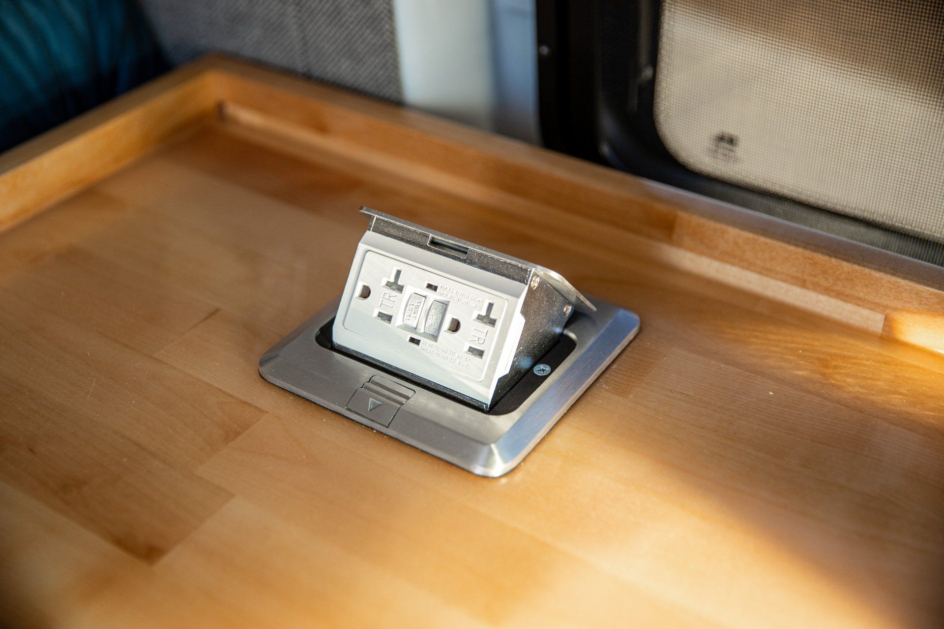 a electrical outlet is sitting on top of a wooden table .