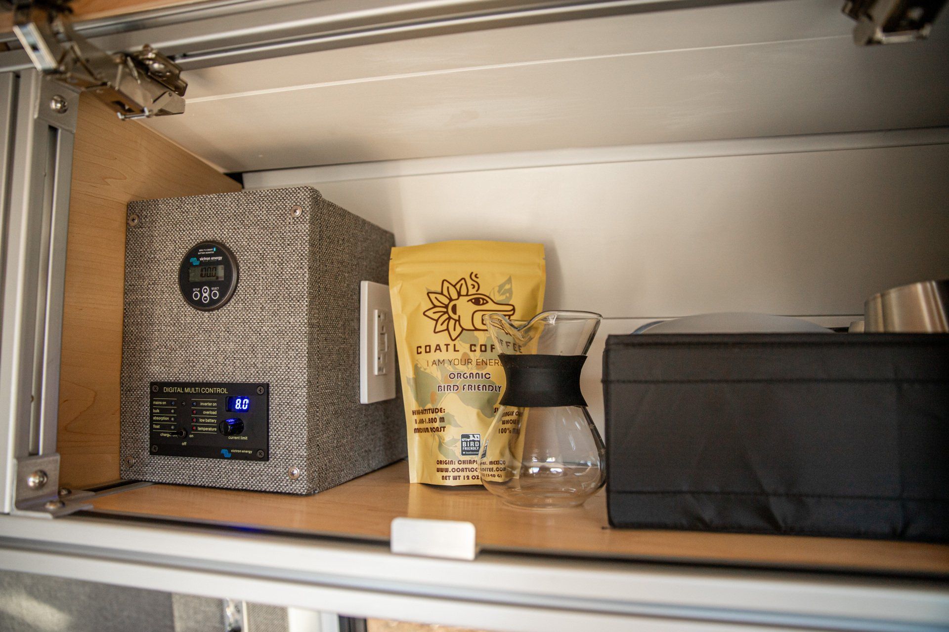 a shelf with a bag of coffee and a coffee pot on it .