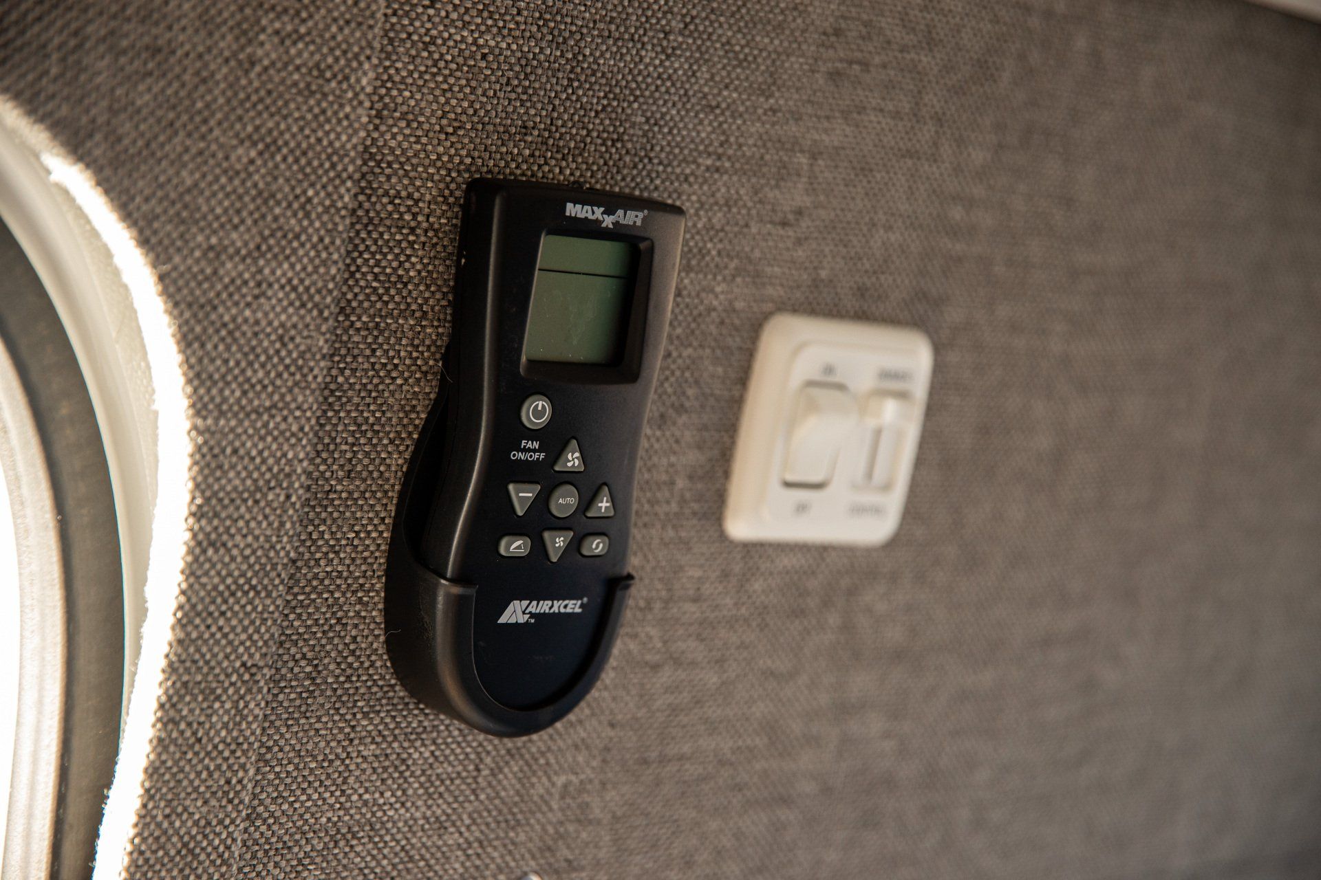 a remote control is mounted on a wall next to a switch