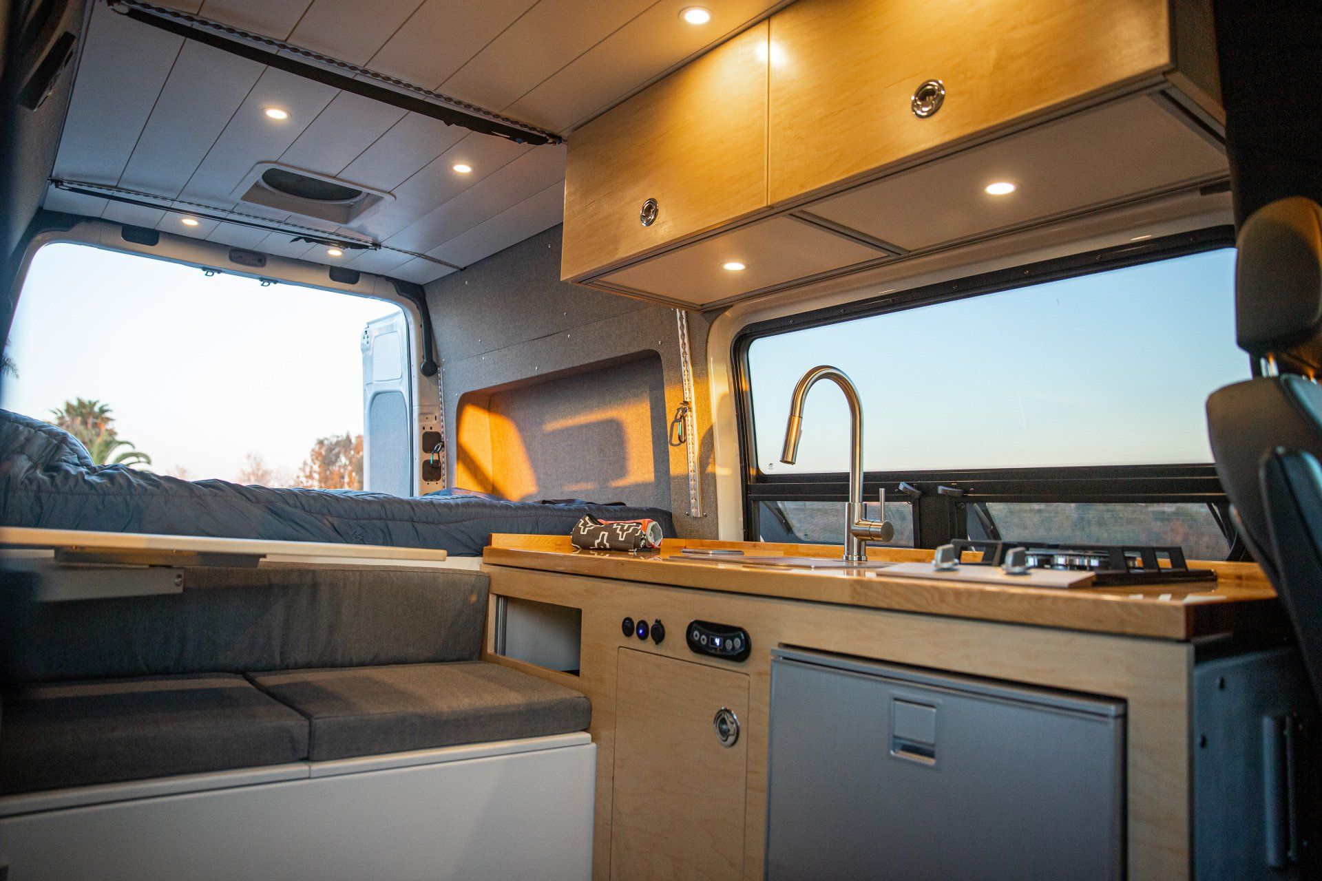the inside of a camper van with a sink and stove .