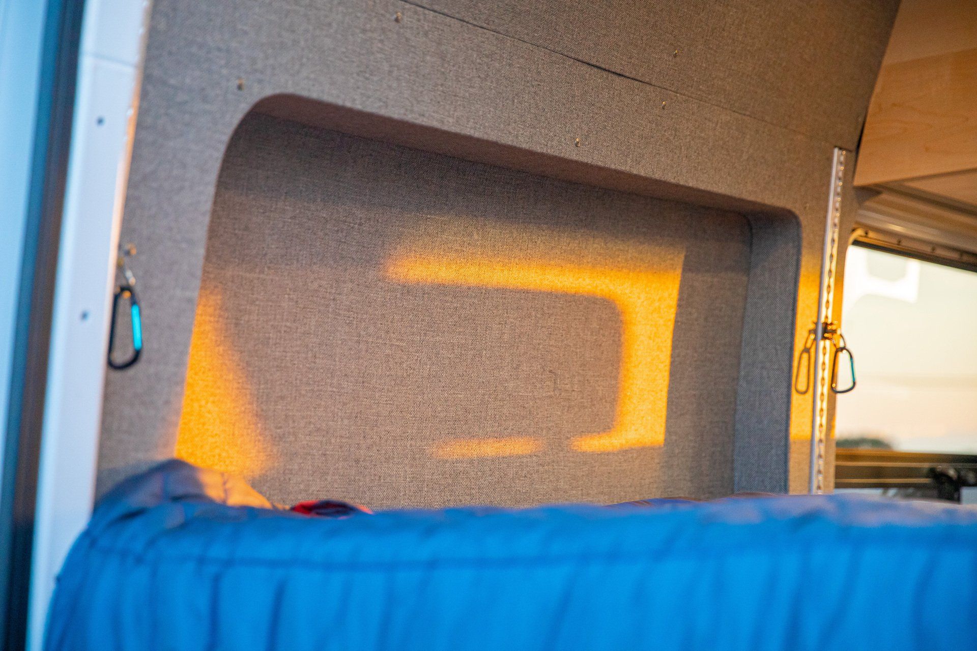 a blue sleeping bag is sitting in the back of a van .