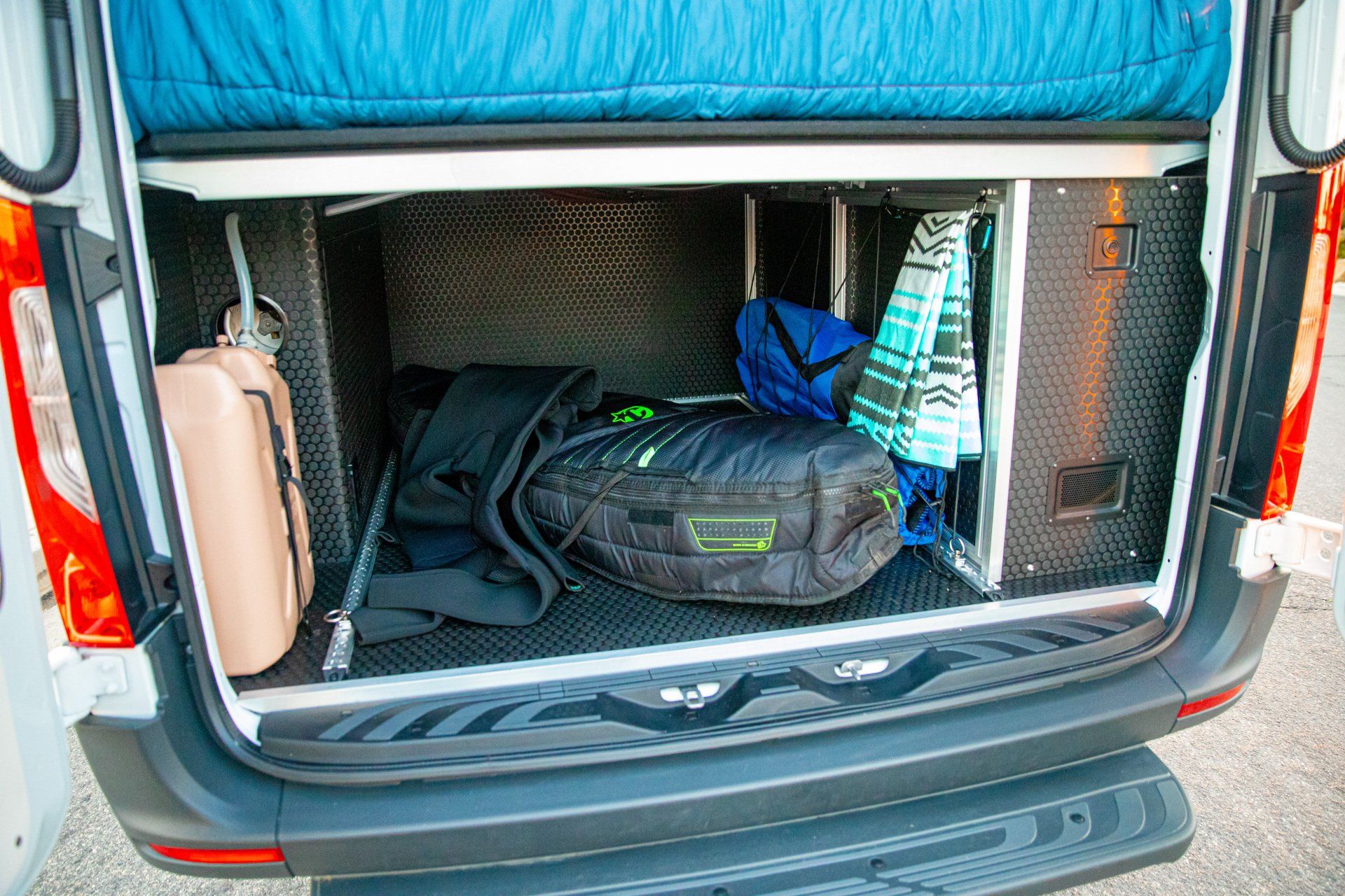 the trunk of a van is filled with luggage and clothes .