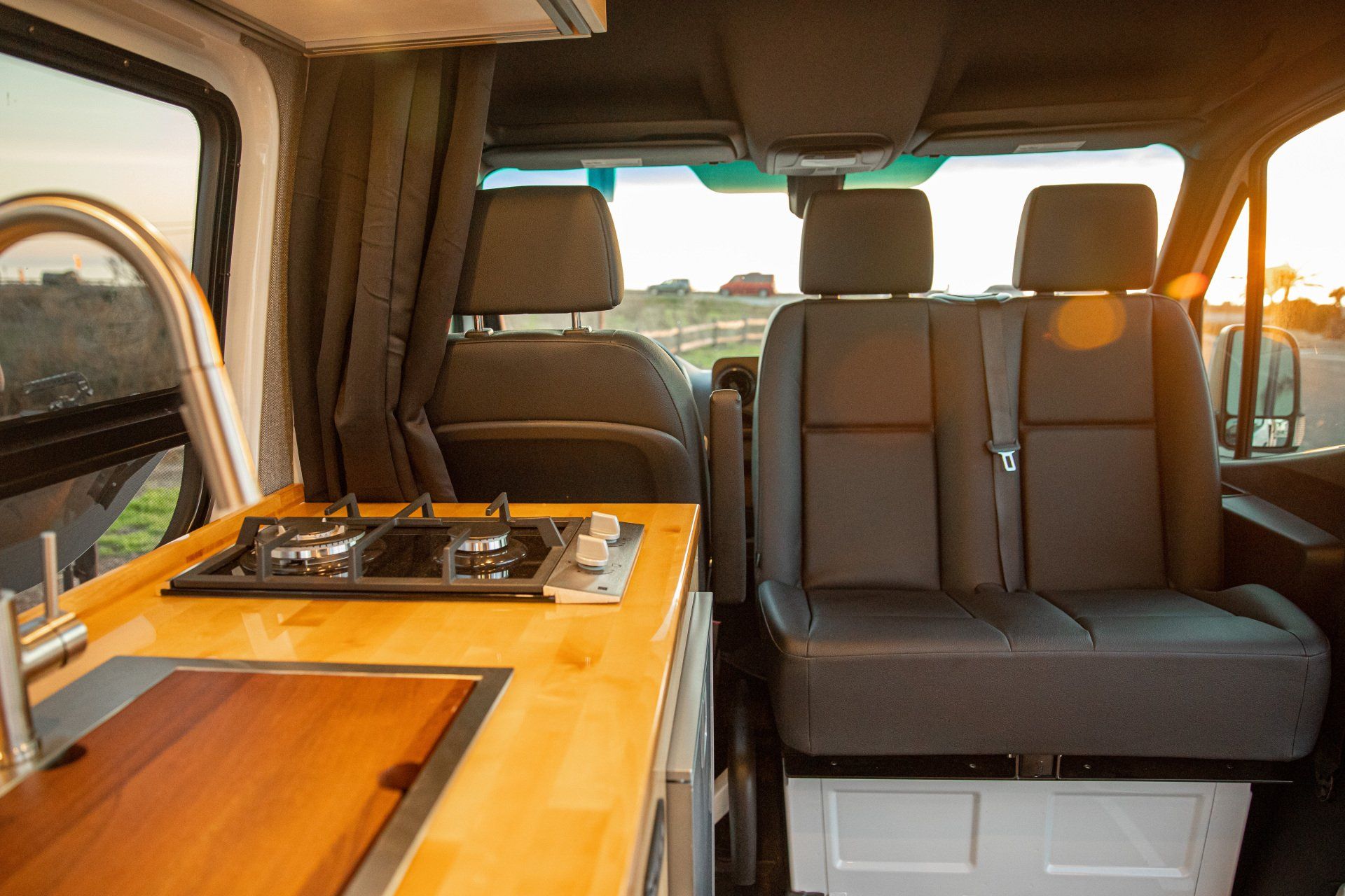 the inside of a van with a kitchen and stove .