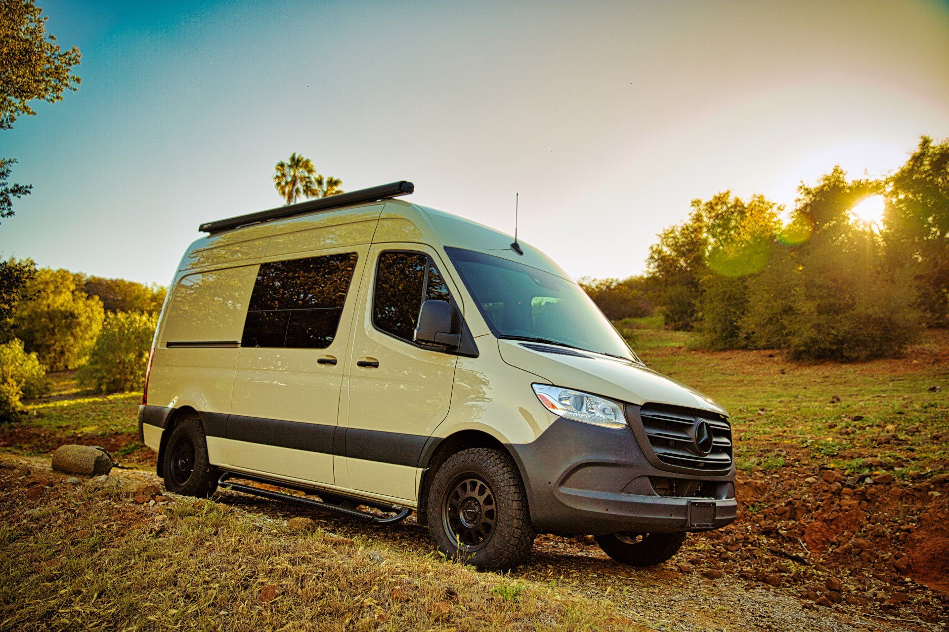 A white van is parked in the middle of a field.