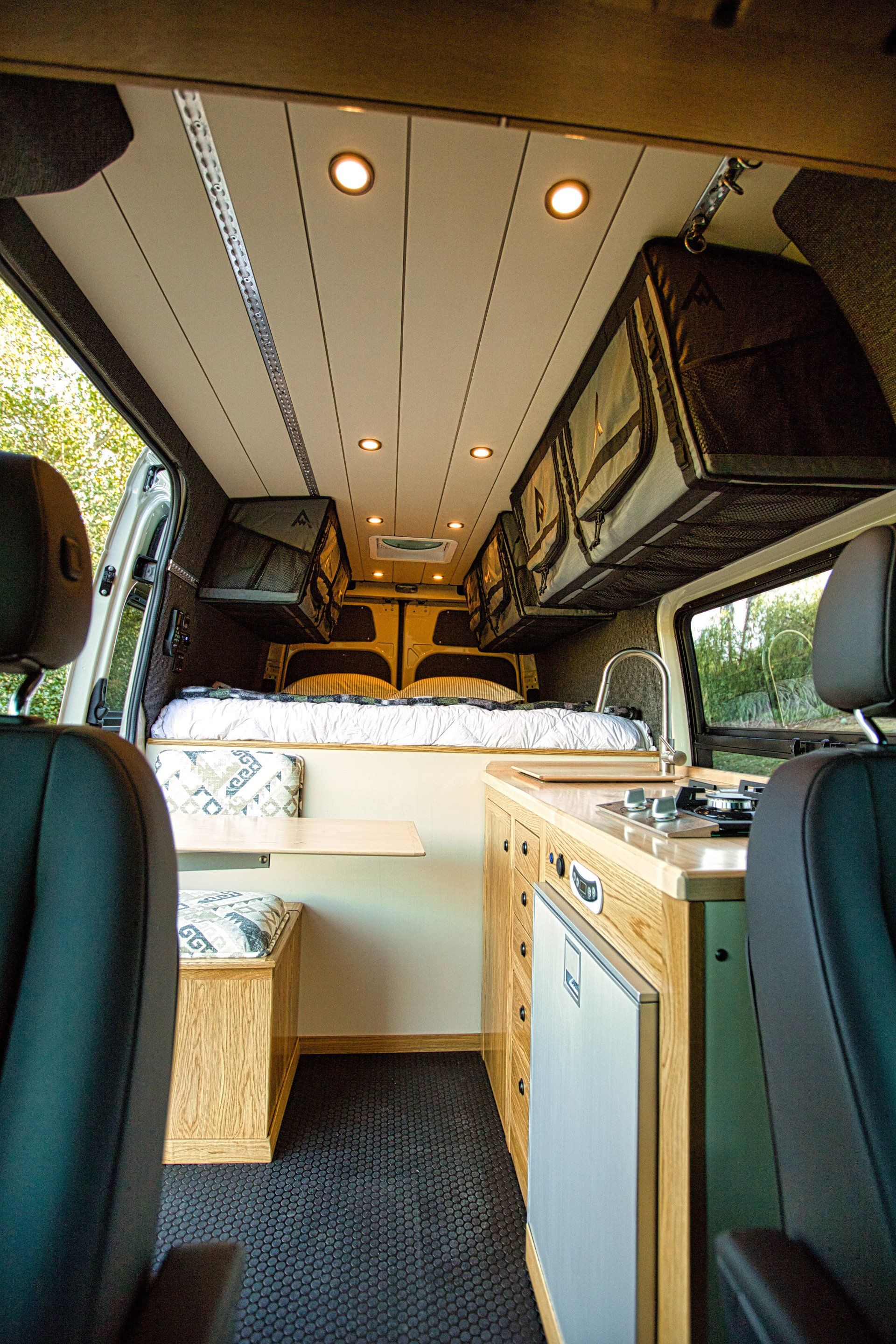 The inside of a van with a bed and a kitchen