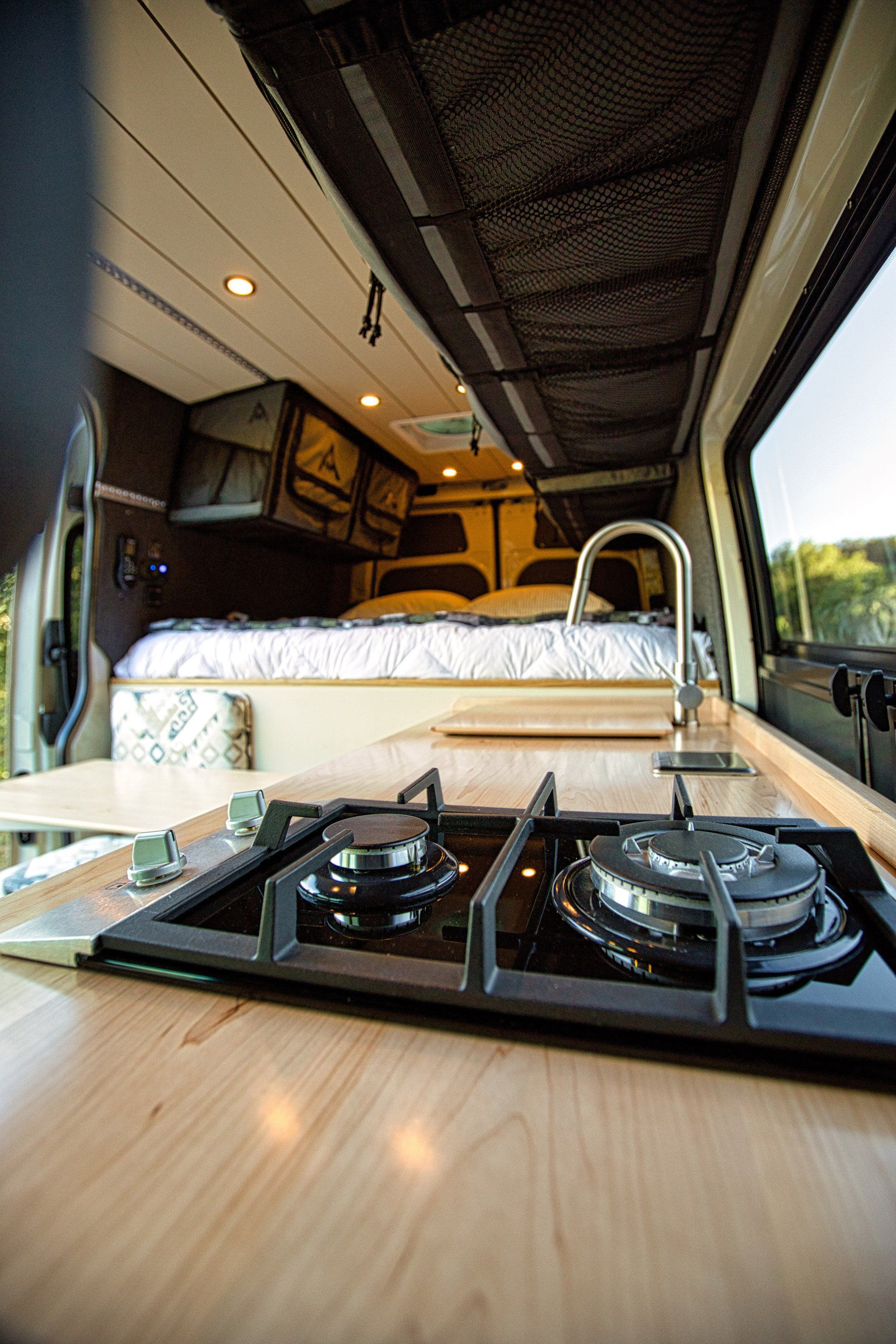 A camper van with a stove top oven and a sink.