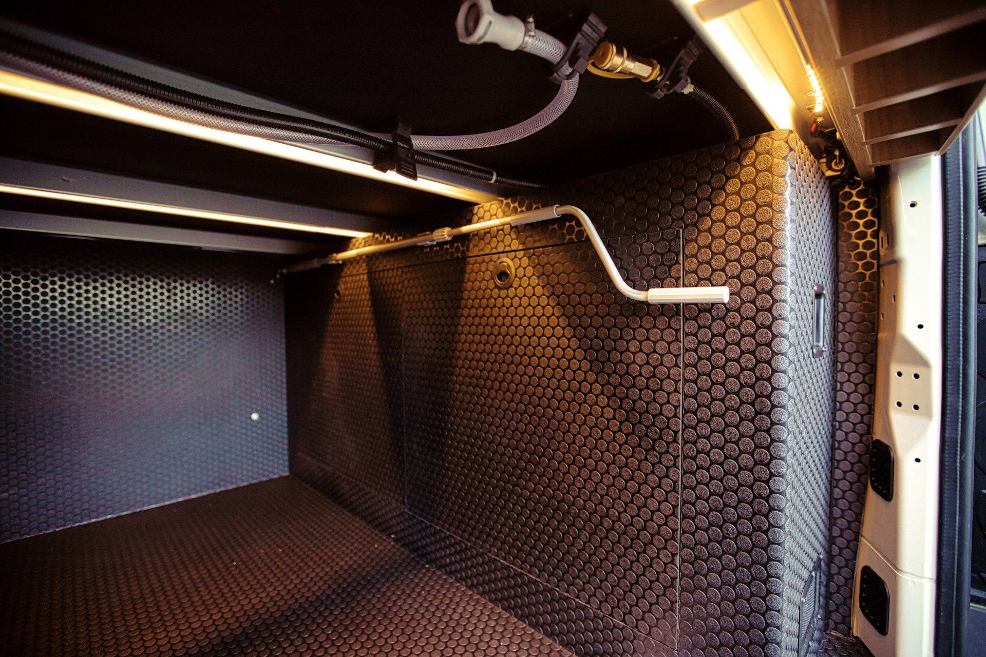 The inside of a van with a hose hanging from the ceiling.