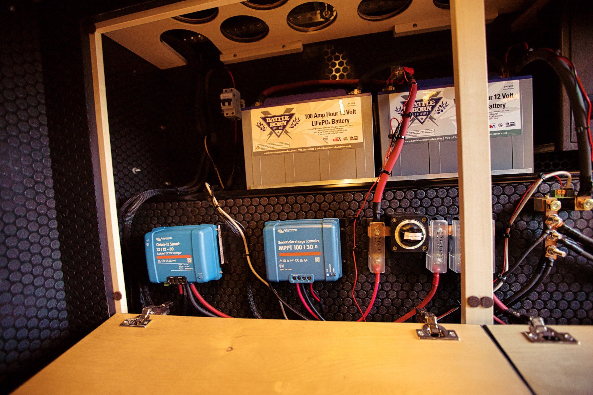 A bunch of wires are connected to a box with a battery on top of it