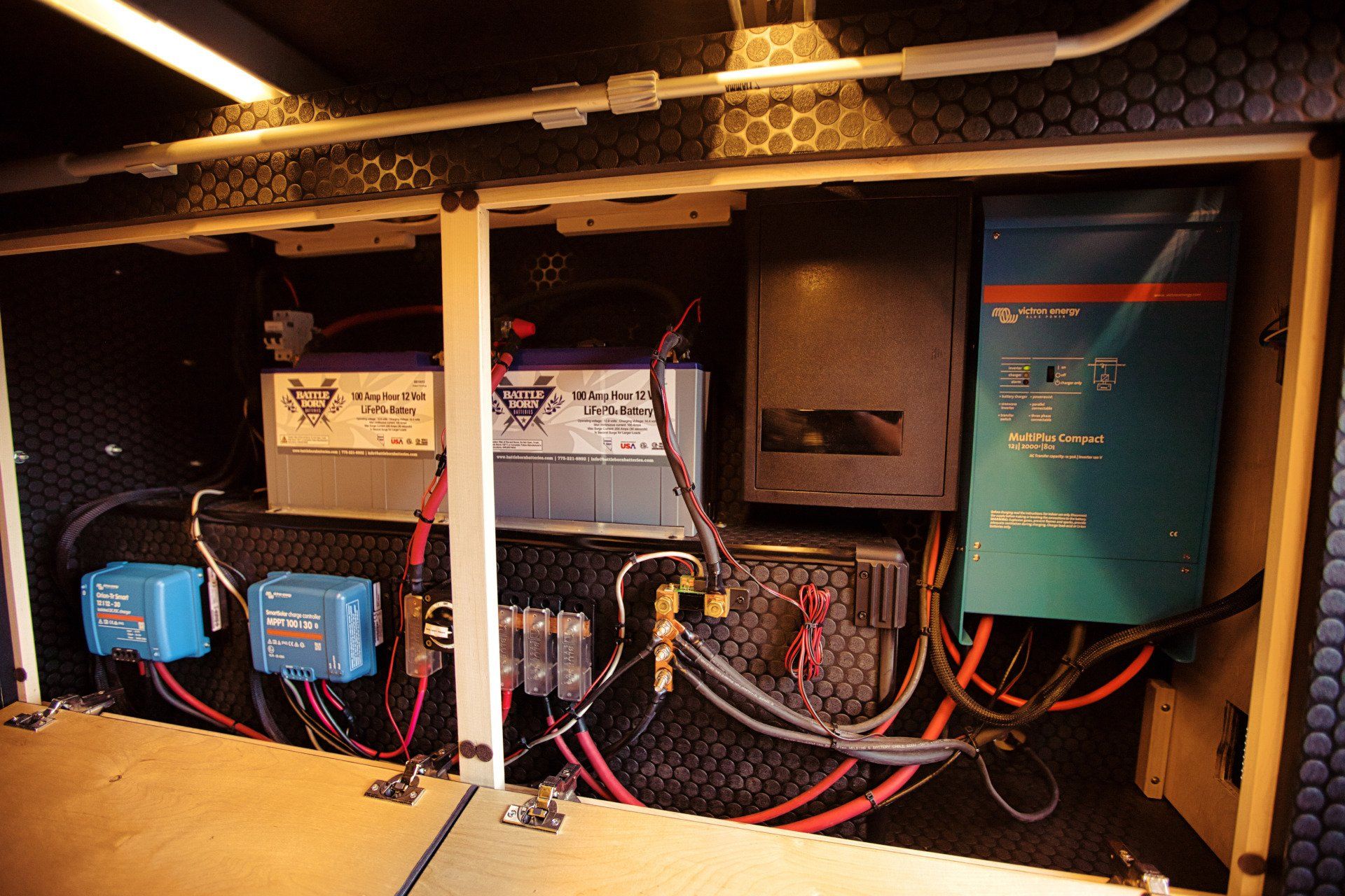 A bunch of wires are coming out of a box with a battery in the middle