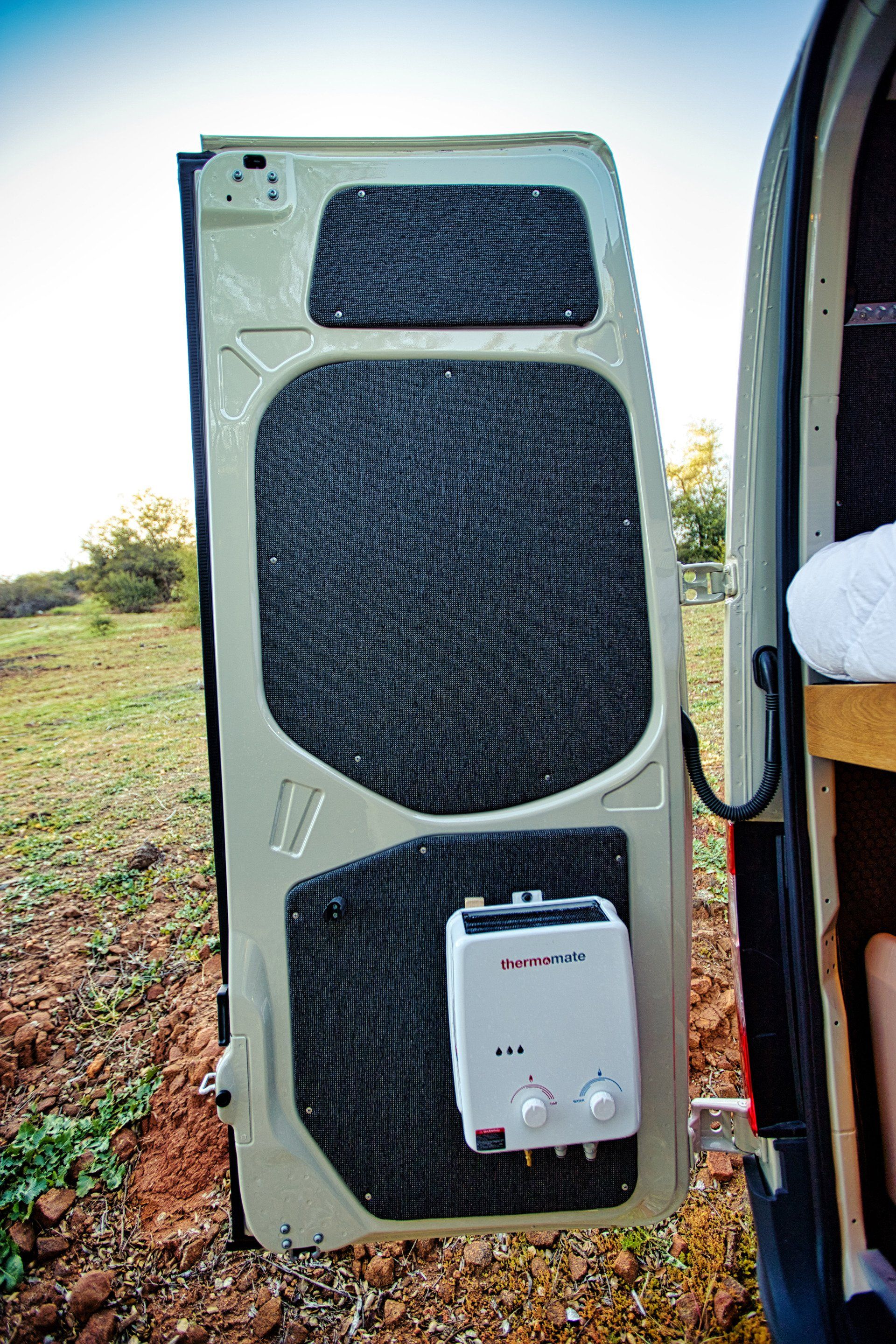 The door of a van with a water heater attached to it.