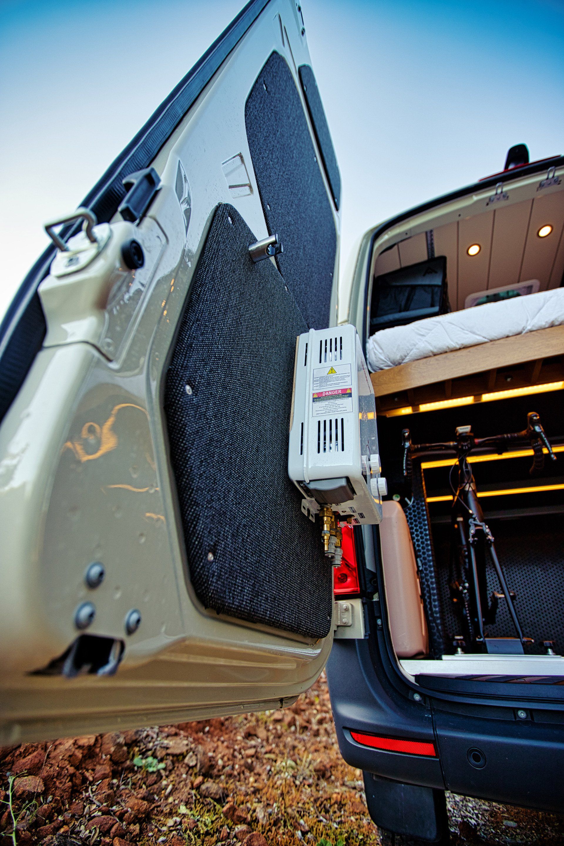 A van with the door open and a bicycle in the back.