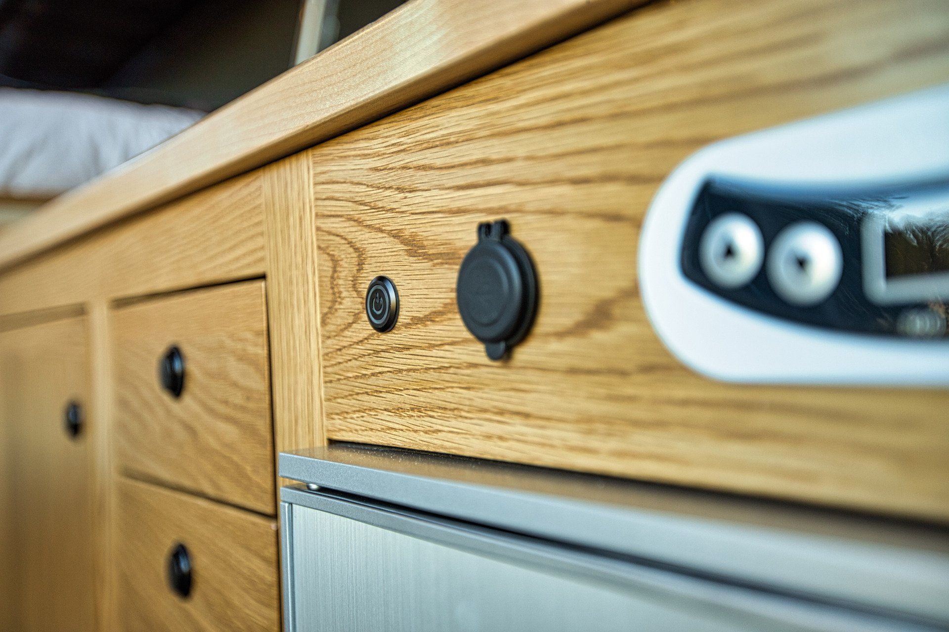 A close up of a wooden cabinet with a stainless steel refrigerator.
