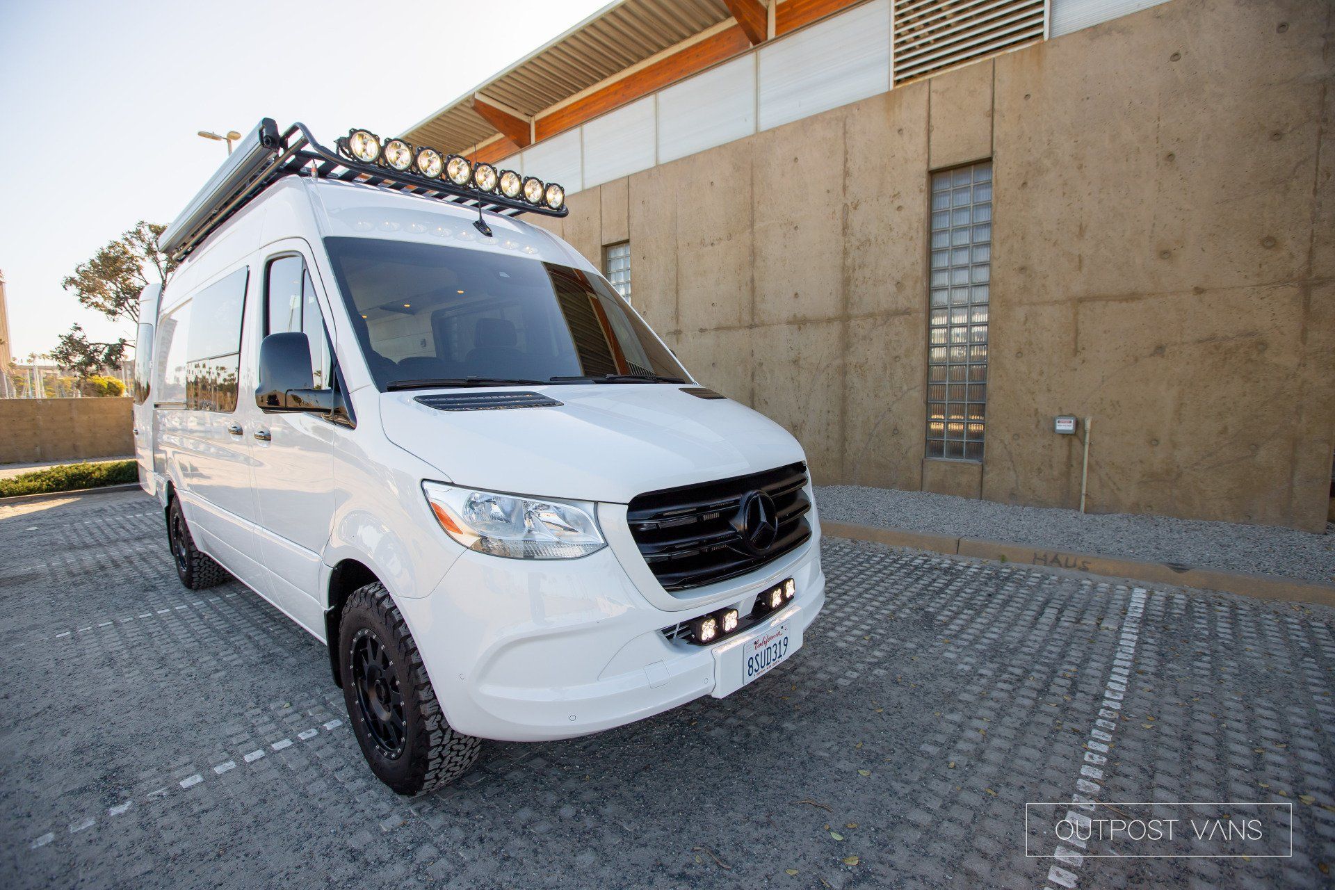 A white van is parked in front of a building.