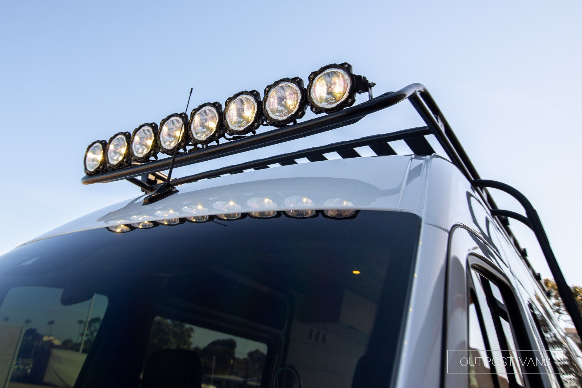 A van with a roof rack and lights on it.
