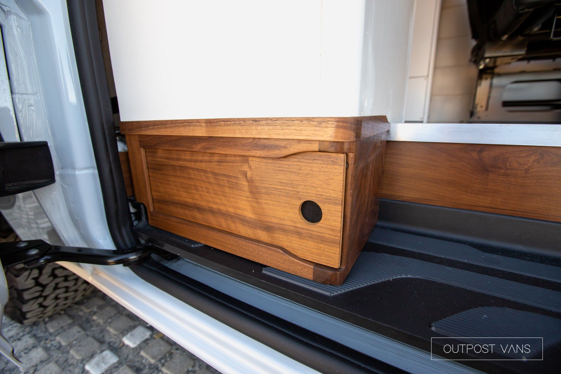 A white van with a wooden cabinet under the door.